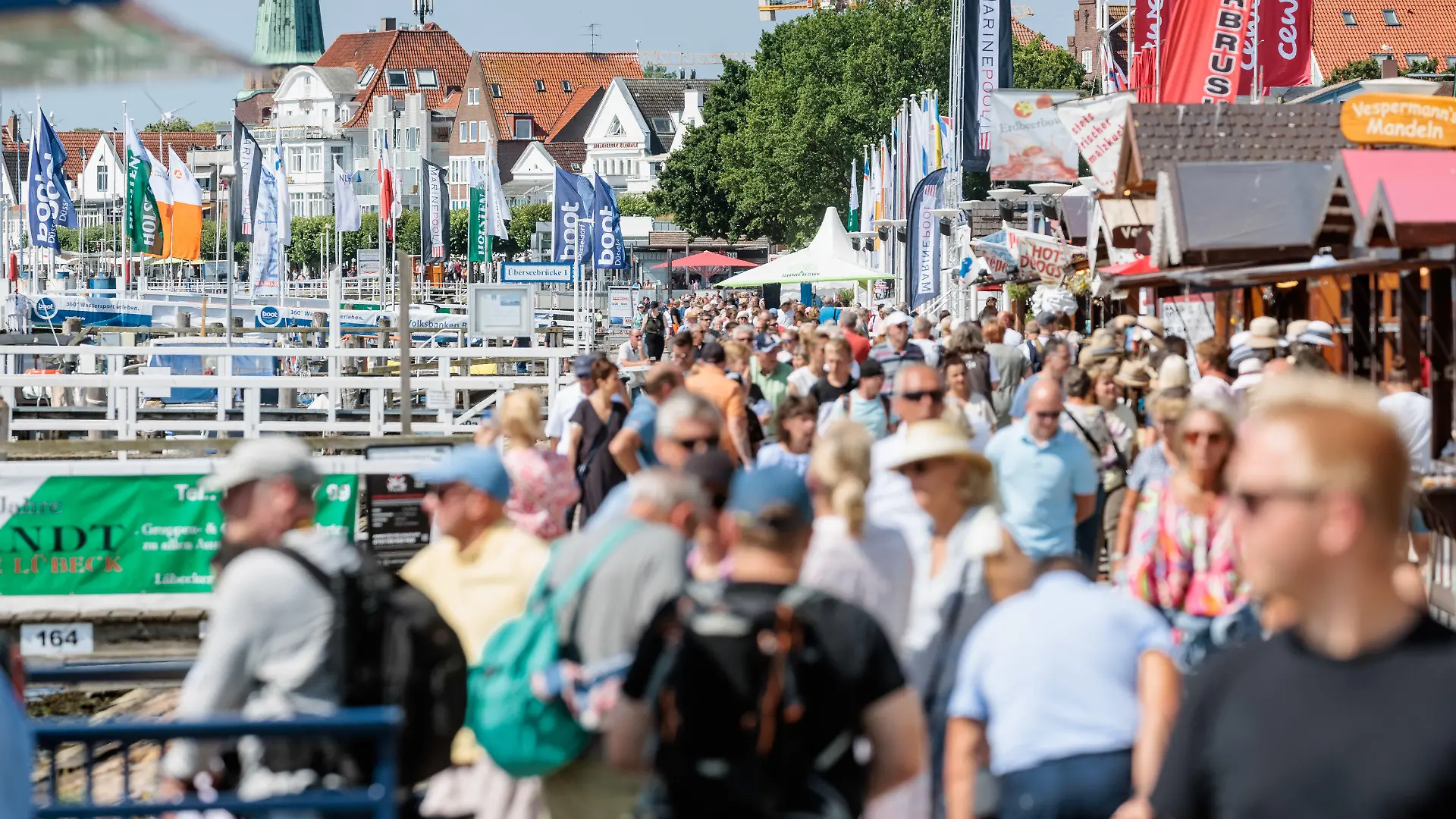 24.07.2022, Schleswig-Holstein, Lübeck-Travemünde: Bei strahlendem Sonnenschein und angenehmen 24 Grad Lufttemperatur flanieren Besucher auf der Travemünder Promenade. Foto: Markus Scholz/dpa +++ dpa-Bildfunk +++