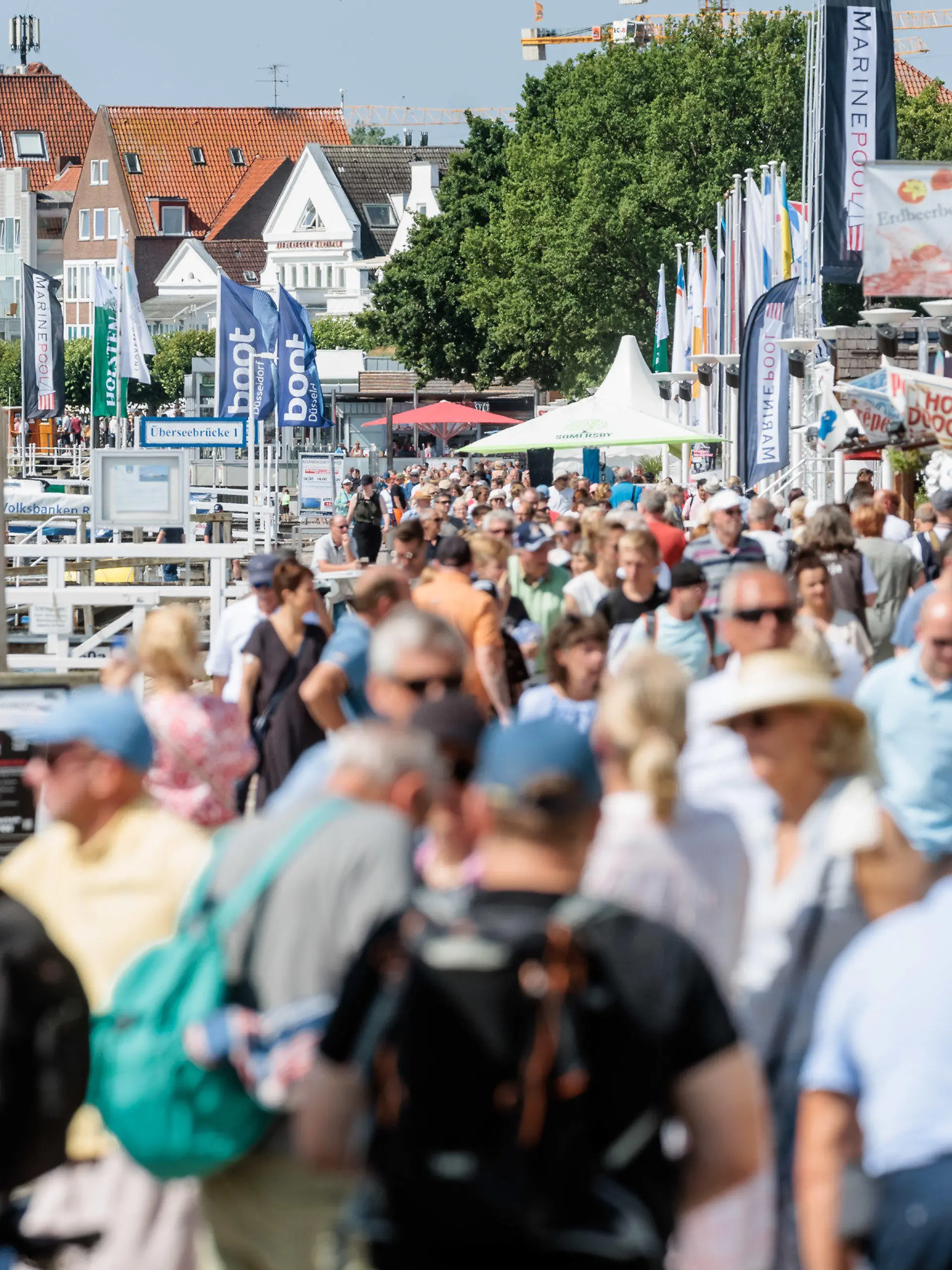24.07.2022, Schleswig-Holstein, Lübeck-Travemünde: Bei strahlendem Sonnenschein und angenehmen 24 Grad Lufttemperatur flanieren Besucher auf der Travemünder Promenade. Foto: Markus Scholz/dpa +++ dpa-Bildfunk +++