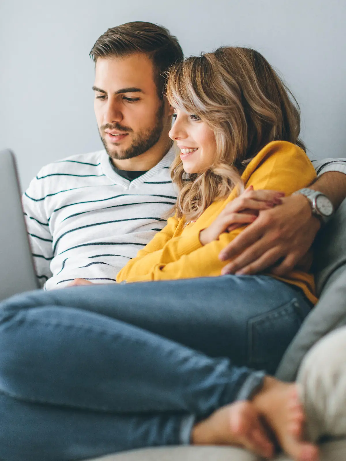 Young cheerful couple using laptop at home