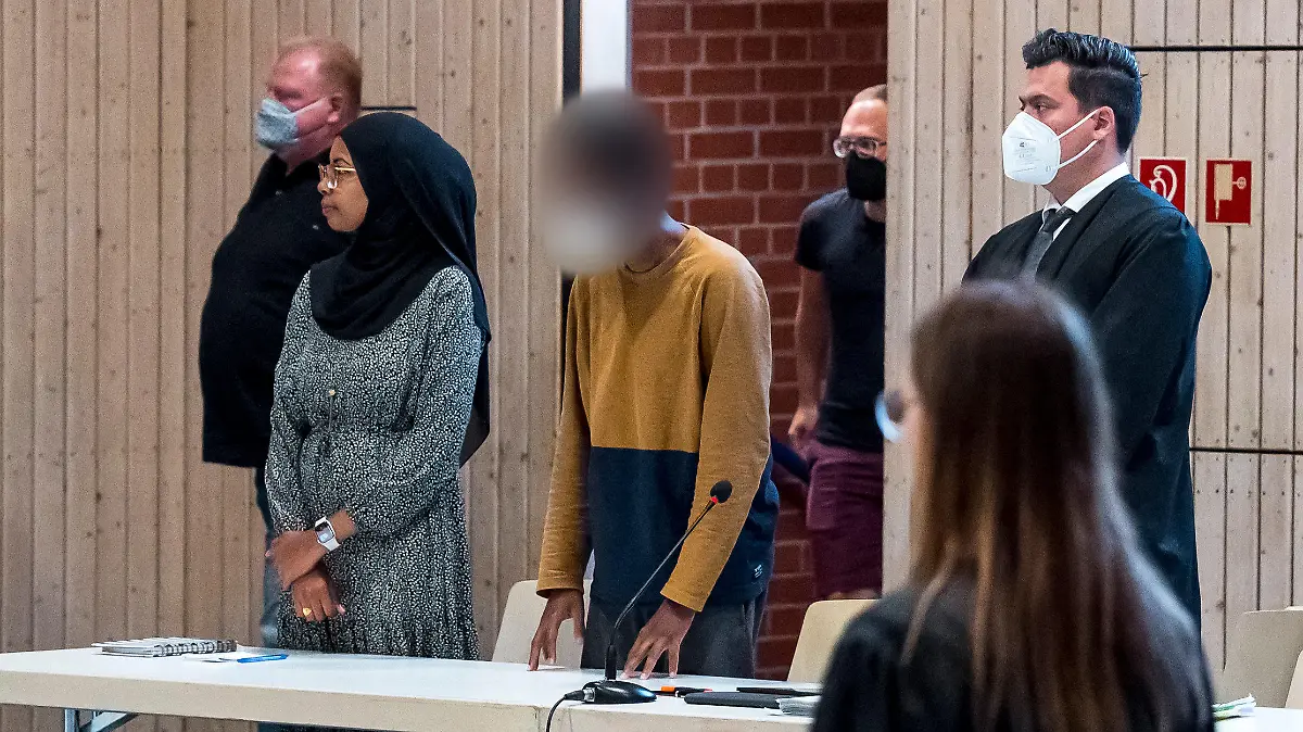 26.07.2022, Bayern, Estenfeld: Der Beschuldigte (M) steht im Verhandlungssaal beim Sicherungsverfahren gegen den Messerstecher von Würzburg, der im Juni 2021 drei Frauen getötet hat. Am Dienstag soll in dem Verfahren ein Urteil fallen. Foto: Daniel Vogl/dpa - ACHTUNG: Der Beschuldigte wurde auf Anordnung des Gerichts gepixelt. +++ dpa-Bildfunk +++