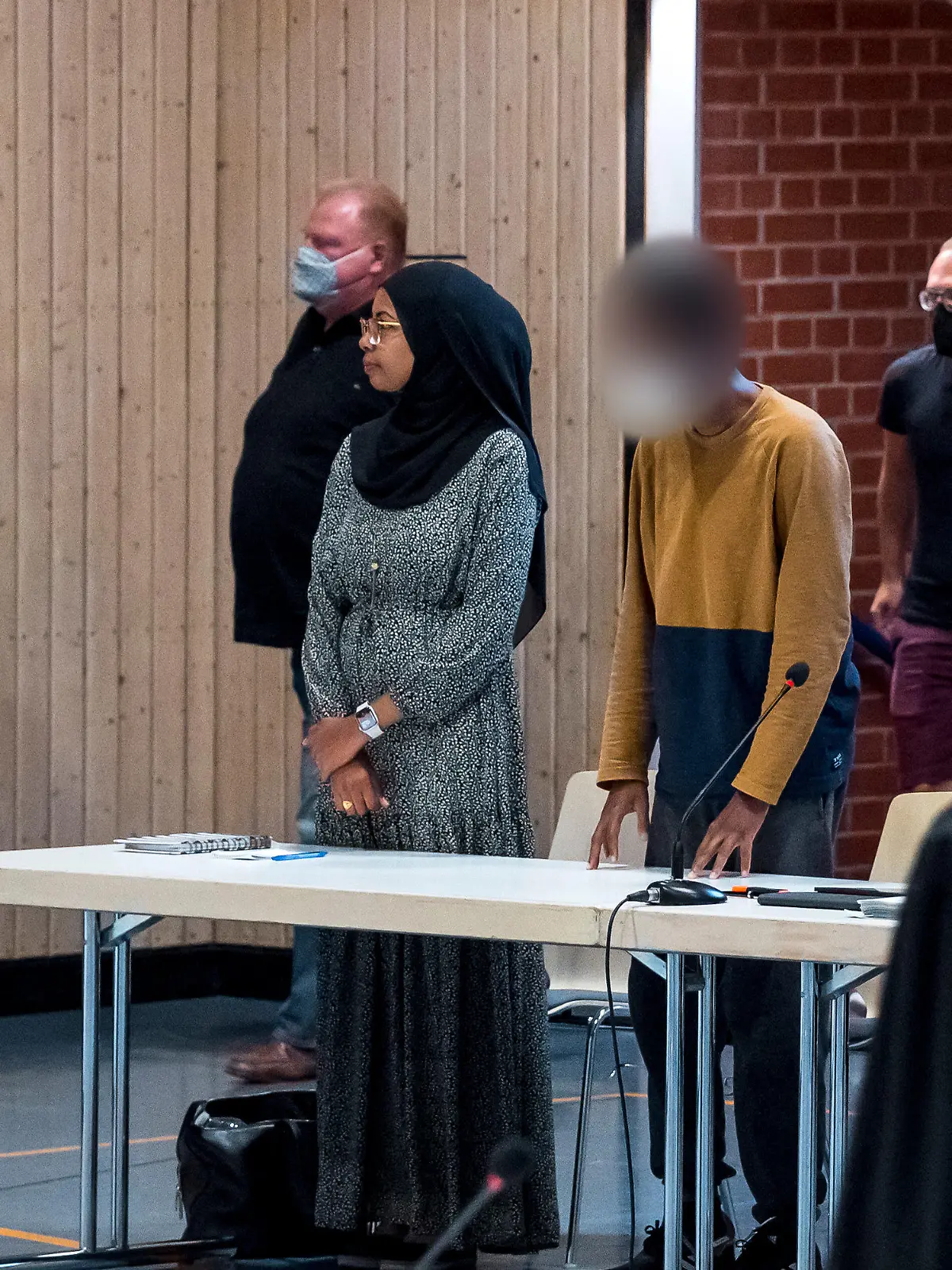 26.07.2022, Bayern, Estenfeld: Der Beschuldigte (M) steht im Verhandlungssaal beim Sicherungsverfahren gegen den Messerstecher von Würzburg, der im Juni 2021 drei Frauen getötet hat. Am Dienstag soll in dem Verfahren ein Urteil fallen. Foto: Daniel Vogl/dpa - ACHTUNG: Der Beschuldigte wurde auf Anordnung des Gerichts gepixelt. +++ dpa-Bildfunk +++