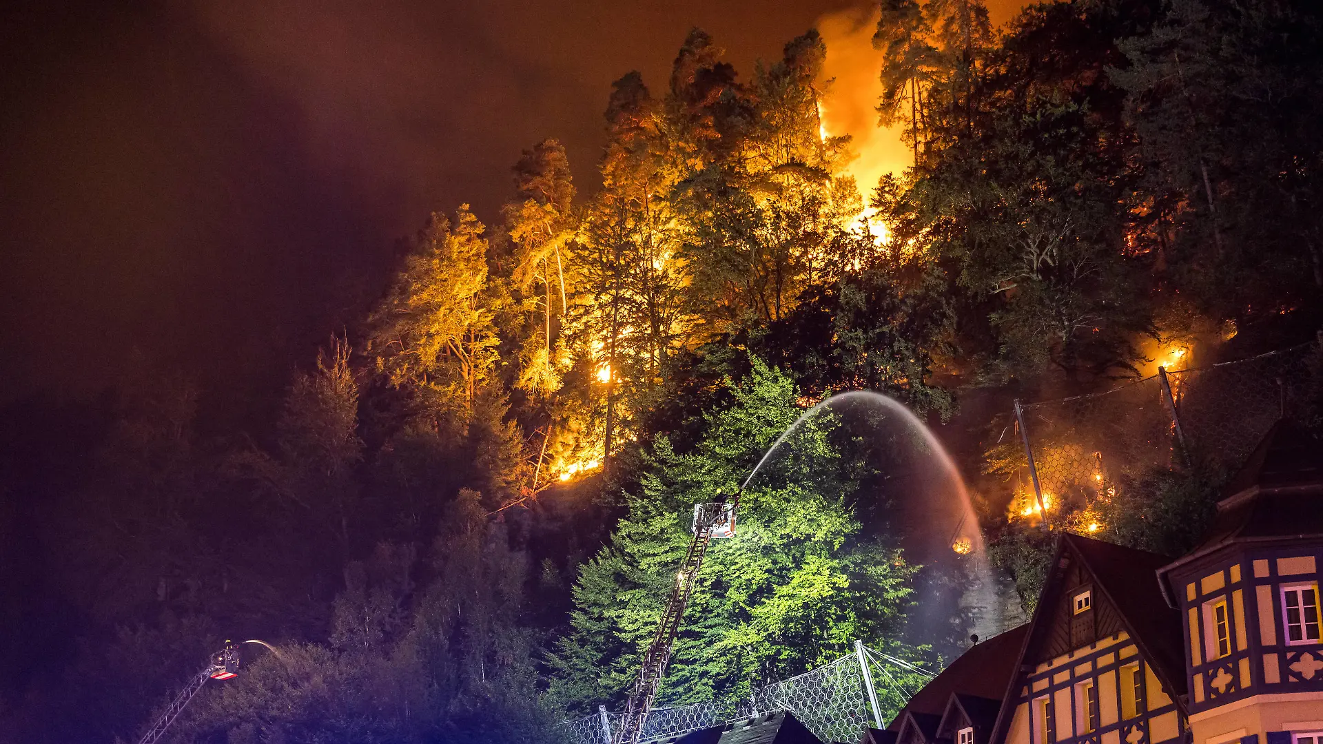 Firefighter throws water on fire in the Ceske Svycarsko Czech Switzerland National Park, in Hrensko, Czech Republic, on Monday, July 25, 2022. The fire broke out on Sunday and started spreading on Monday as the wind rose. CTKxPhoto/VojtechxHajek CTKPhotoP2022072600585 PUBLICATIONxNOTxINxCZExSVK HAJ 21