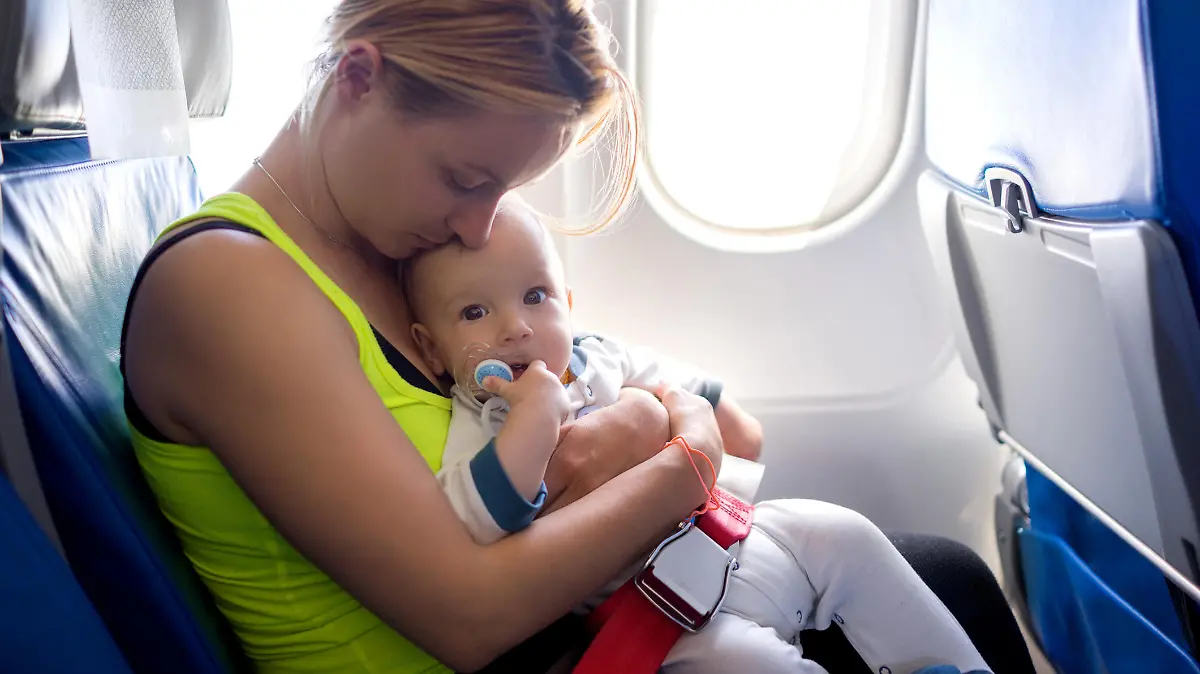Young mother and her baby boy traveling by plane.