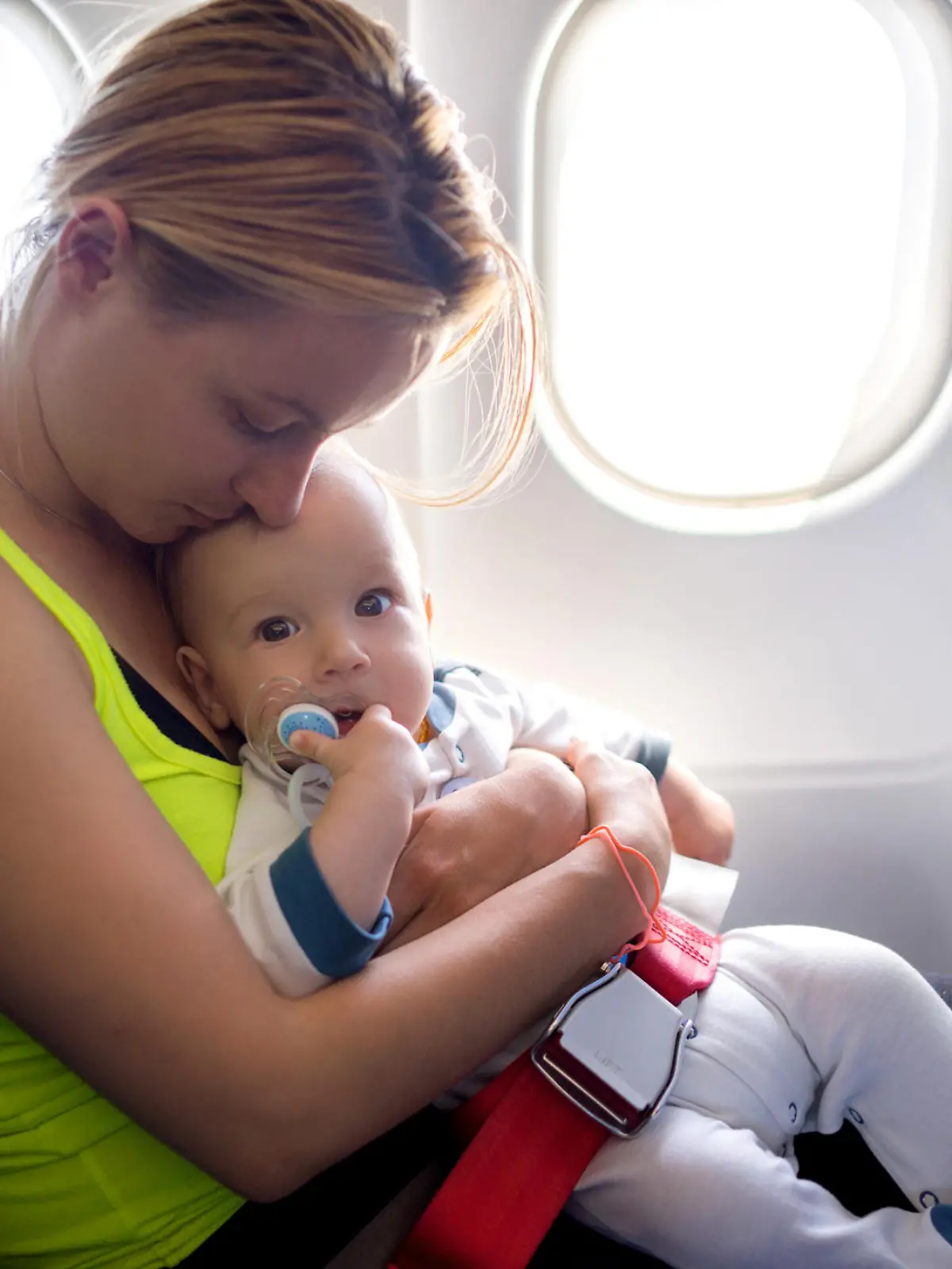 Young mother and her baby boy traveling by plane.