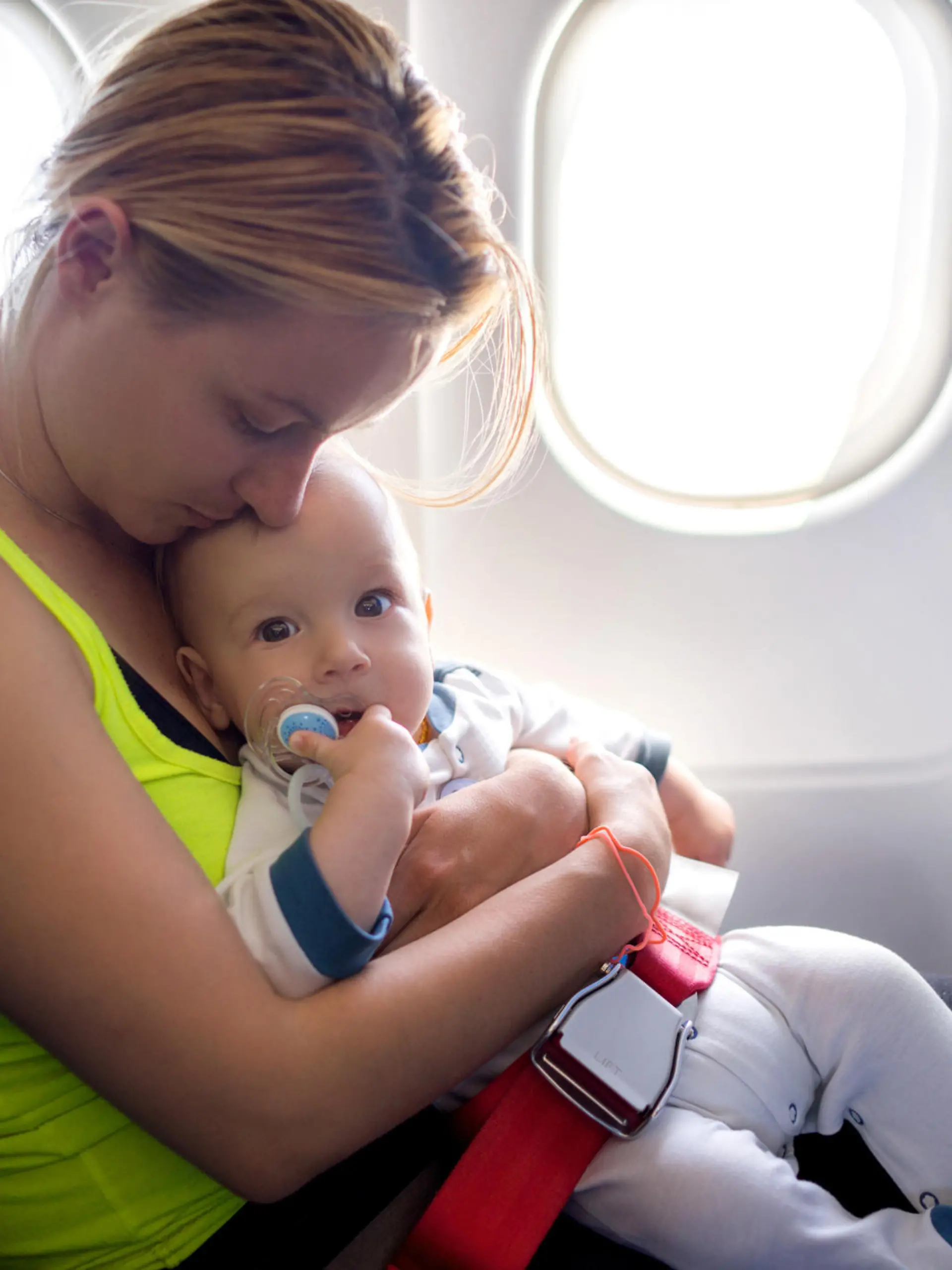 Young mother and her baby boy traveling by plane.