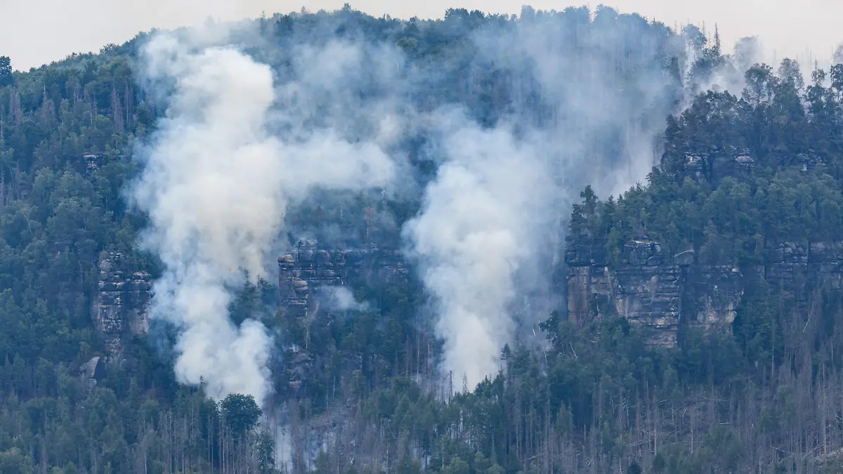 26.07.2022, Sachsen, Schmilka: Der Wald brennt im Nationalpark Sächsische Schweiz. Der Waldbrand im Nationalpark Sächsische Schweiz hat sich ausgeweitet. Für Bad Schandau sei Katastrophenalarm ausgelöst worden, sagte ein Sprecher des Landratsamtes Landkreis Sächsische Schweiz-Osterzgebirge am Dienstagmorgen. Foto: Robert Michael/dpa +++ dpa-Bildfunk +++