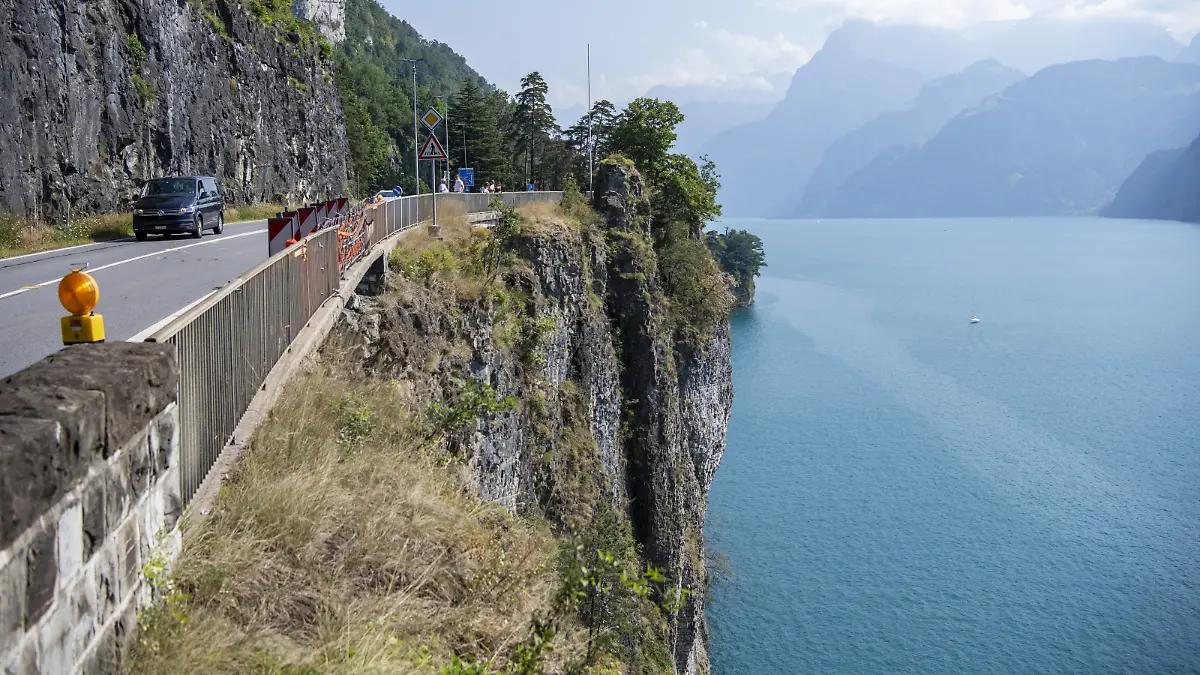 Ansicht der Unfallstelle bei der Axenstrasse, bei der ein Auto zwischen dem Moositunnel und Wolfsprung von der Fahrbahn abkam, das Gelaender durchschlug und rund 45 Meter hinab in den Vierwaldstaettersee stuertzte, am Sonntag, 24. Juli 2022, in Brunnen SZ. Das Auto und die Insassen wurden bisher noch nicht geortet, es wird vermutet, dass das Auto auf rund 180 Meter Tiefe liegt. (KEYSTONE/Urs Flueeler)