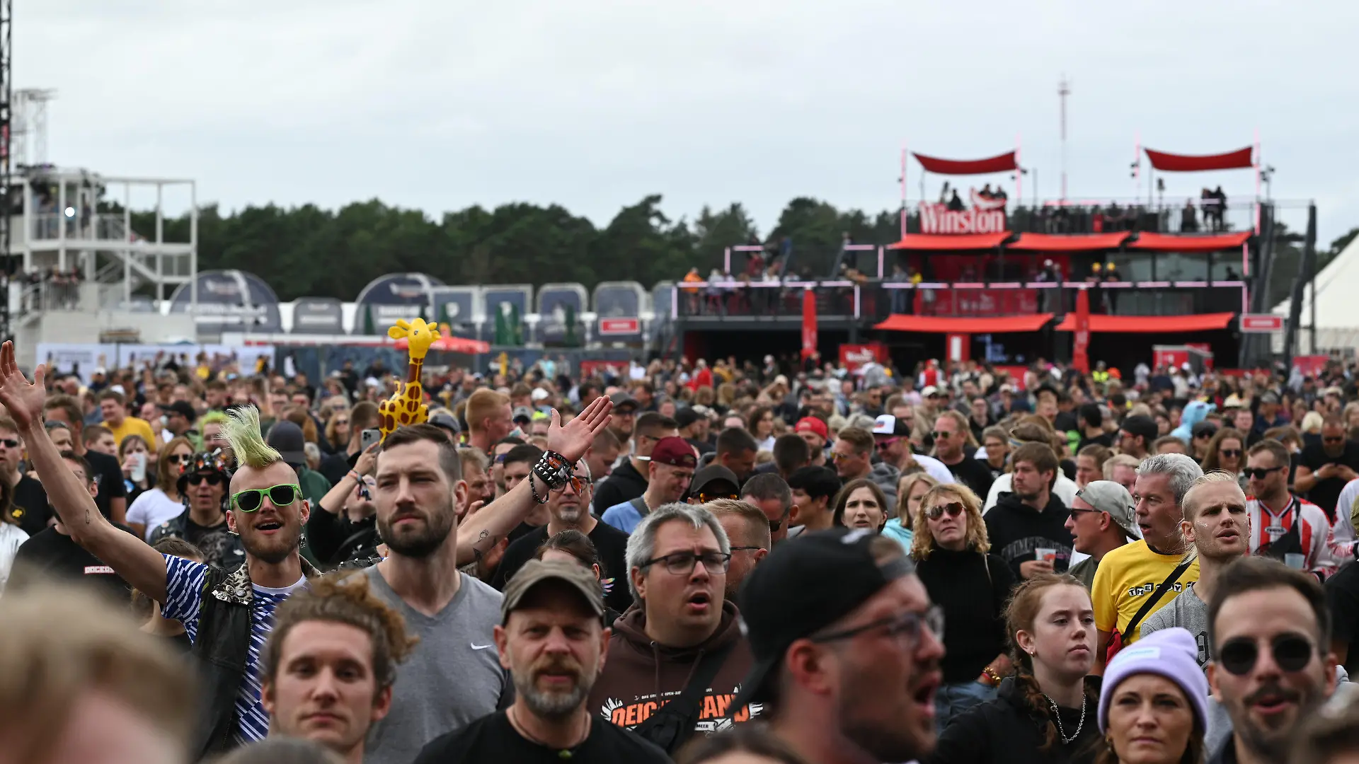 22.07.2022, Niedersachsen, Nordholz: Besucher gehen über das Festivalgelände des Deichbrand Rockfestival am Meer am zweiten Tag. Das Open-Air an der Nordsee bietet bis zu 100 Acts auf den fünf Bühnen auf dem Seeflughafen (Sea-Airport) Cuxhaven/Nordholz. Täglich werden etwa 60 000 Festivalgänger erwartet. Foto: Lars Klemmer/dpa +++ dpa-Bildfunk +++