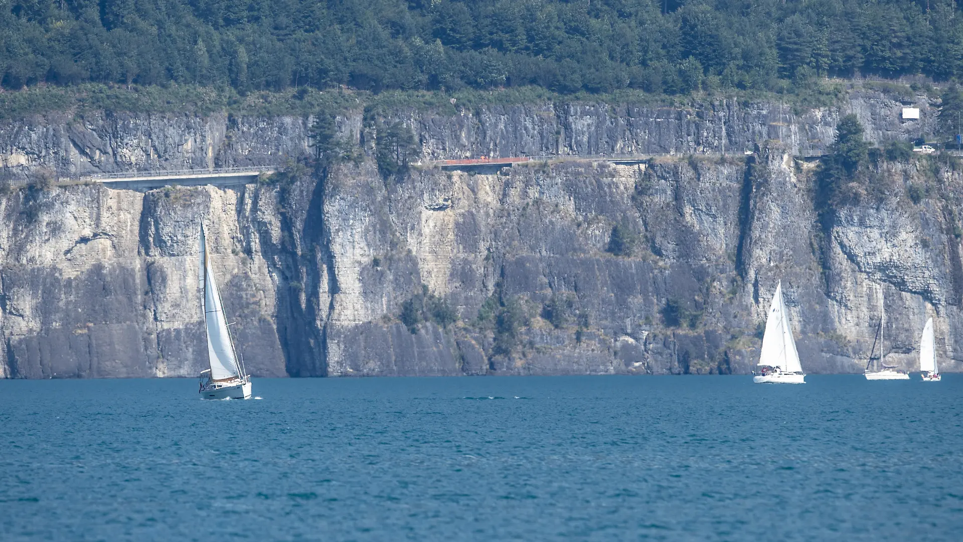 Ansicht der Unfallstelle auf der Axenstrasse, bei der ein Auto zwischen dem Moositunnel und Wolfsprung von der Fahrbahn abkam, das Gelaender durchschlug und rund 45 Meter hinab in den Vierwaldstaettersee stuertzte, am Sonntag, 24. Juli 2022, in Brunnen SZ. Das Auto und die Insassen wurden bisher noch nicht geortet, es wird vermutet, dass das Auto auf rund 180 Meter Tiefe liegt. (KEYSTONE/Urs Flueeler)
