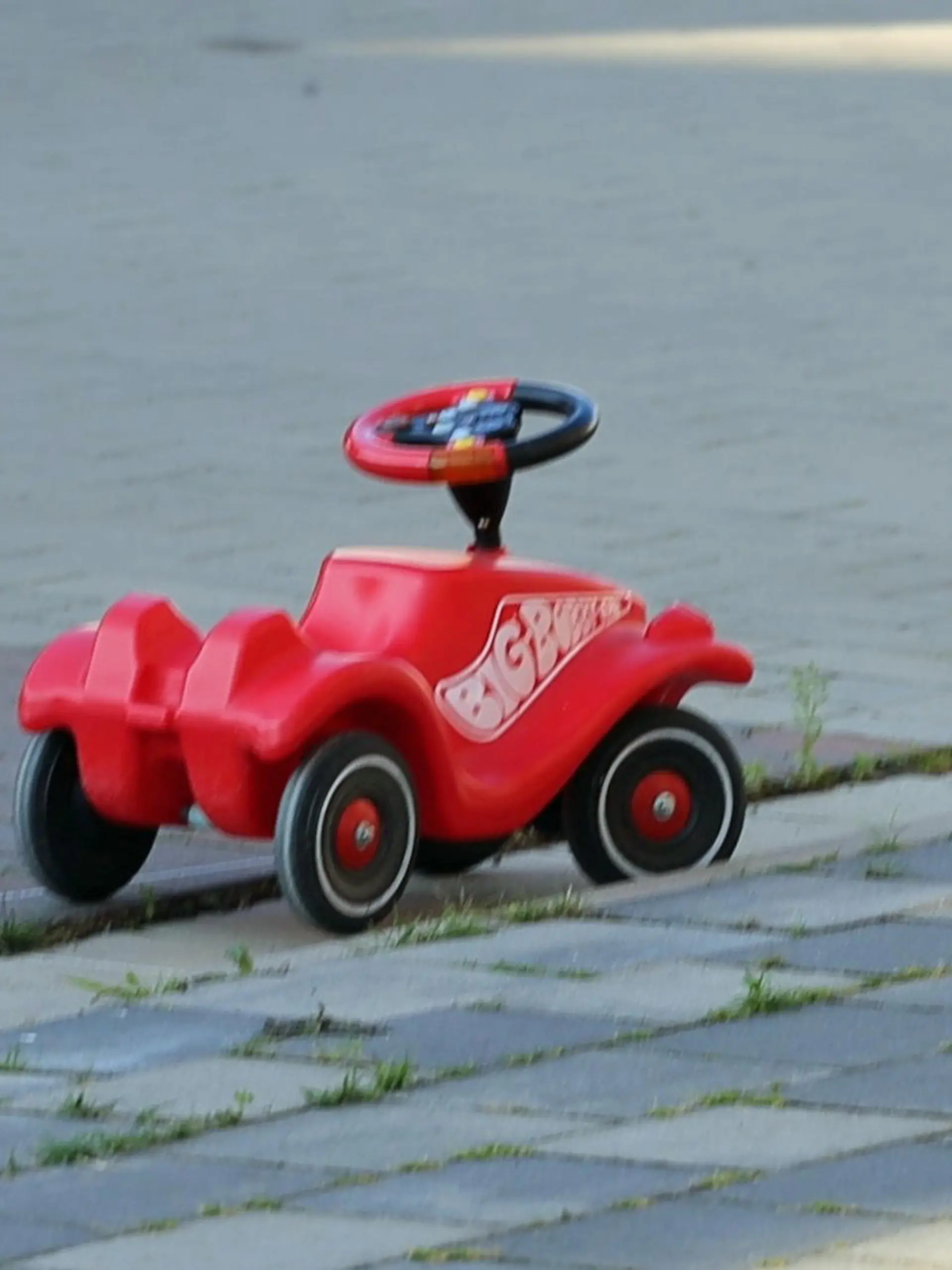 24.07.2022, Niedersachsen, Bohmte: Ein Bobbycar steht an einer verkehrsberuhigten Straße in Bohmte. Nach einem tödlichen Unfall in Bohmte im Landkreis Osnabrück, bei dem ein einjähriges Mädchen von einem Wagen überrollt wurde, hat die Polizei bei dem Autofahrer einen Atemalkoholwert von 0,8 Promille gemessen. Das Kleinkind war mit einem Bobbycar von einem Grundstück in einen verkehrsberuhigten Bereich gerollt. Dort kam es zum Zusammenstoß. Foto: Heinz-Jürgen Reiss/Nord-West-Media TV/dpa +++ dpa-Bildfunk +++