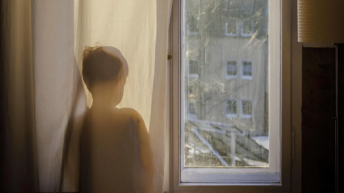 Symbolfoto zum Thema Psychologie bei Kindern. Ein Junge steht am Fenster hinter einem Vorhang und schaut hinaus. Berlin, 22.01.2022 Berlin Deutschland *** Child psychology symbol photo A boy stands at the window behind a curtain and looks out Berlin, 22 01 2022 Berlin Germany Copyright: xThomasxTrutschel/photothek.dex 