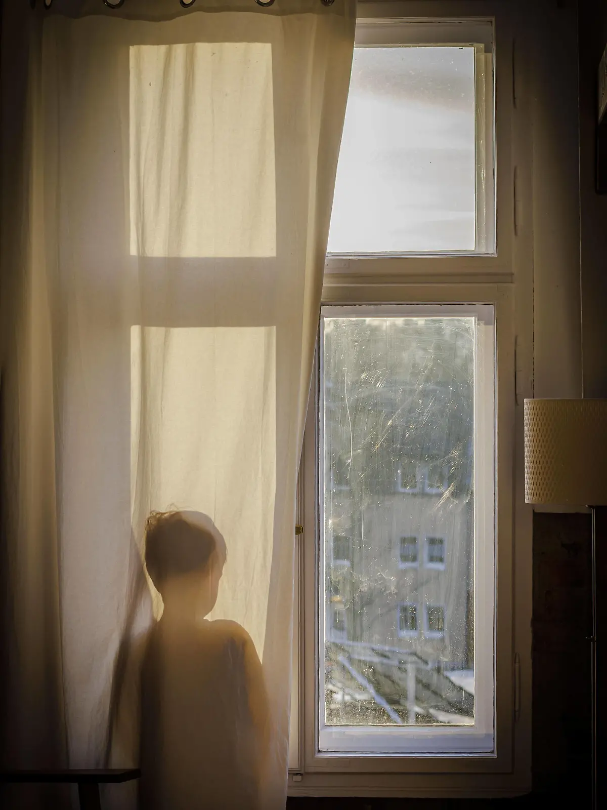 Symbolfoto zum Thema Psychologie bei Kindern. Ein Junge steht am Fenster hinter einem Vorhang und schaut hinaus. Berlin, 22.01.2022 Berlin Deutschland *** Child psychology symbol photo A boy stands at the window behind a curtain and looks out Berlin, 22 01 2022 Berlin Germany Copyright: xThomasxTrutschel/photothek.dex 