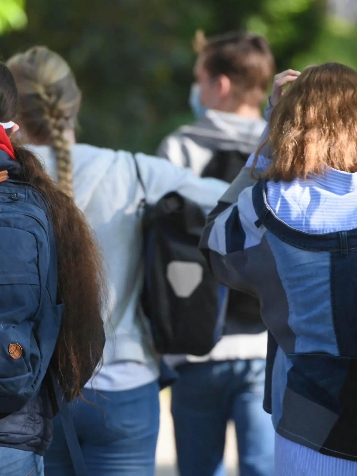 ACHTUNG: SPERRFRIST 8. DEZEMBER 00:01 UHR. FREI FÜR ZEITUNGSAUSGABEN AM DIENSTAG - ARCHIV - 18.05.2020, Hessen, Frankfurt/Main: Schülerinnen und Schüler eines Gymnasiums  gehen vor dem Schulgebäude und tragen dabei Masken. (Zu dpa "Jugendliche fordern mehr Unterstützung in der Krise") Foto: Arne Dedert/dpa +++ dpa-Bildfunk +++