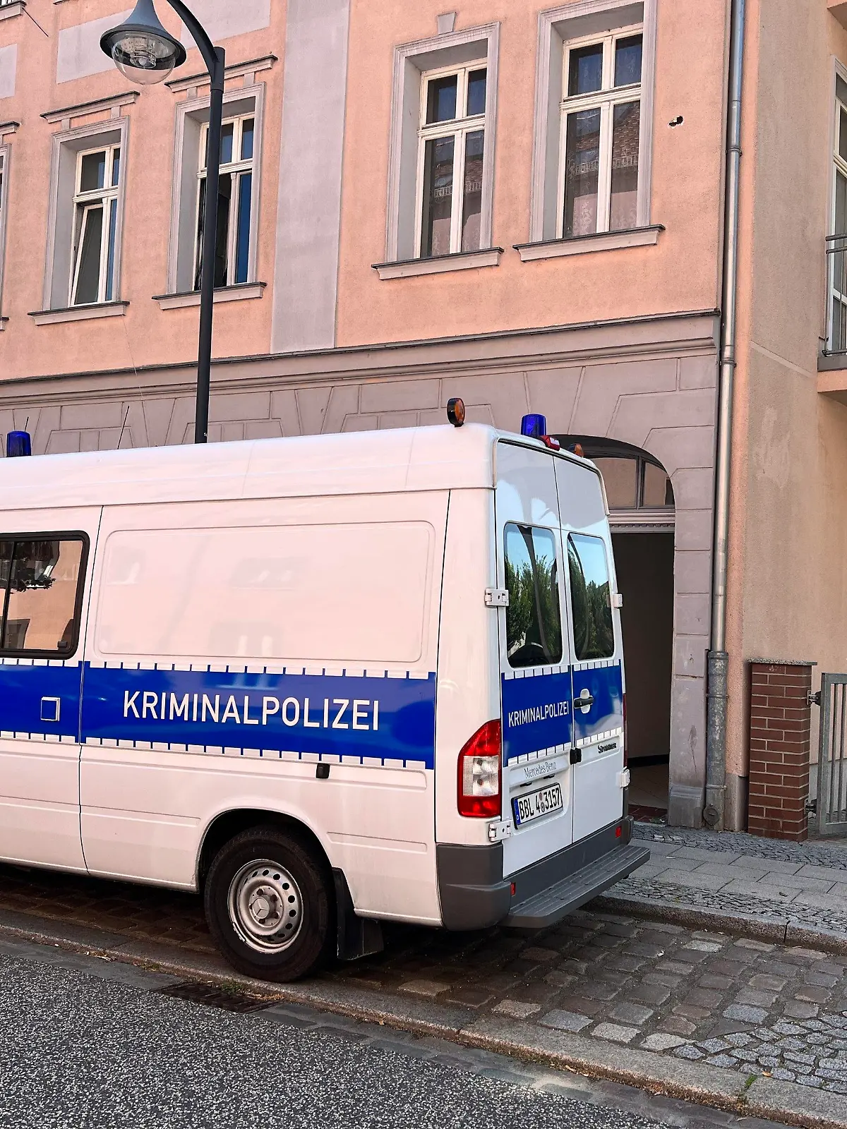 25.07.2022, Brandenburg, Fürstenwalde: Ein Transporter der Kriminalpolizei steht nahe des Fundortes.Die Polizei hat in Fürstenwalde (Oder-Spree) einen Toten entdeckt. Der Mann sei am Montagmorgen auf einem Hinterhof in der Gartenstraße mit massiven Verletzungen aufgefunden worden, wie die Polizeidirektion Ost mitteilte. Ersten Erkenntnissen zufolge könnte es sich um einen 43-Jährigen handeln. Foto: Blp / Sappeck/dpa +++ dpa-Bildfunk +++