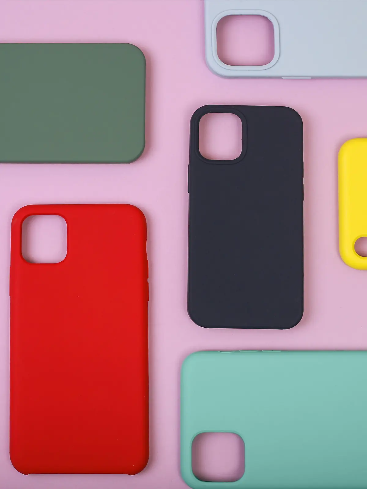 Colored silicone phone cases. Up to date technology.Close up of diverse personal accessory laying on the lavender background. Flat lay