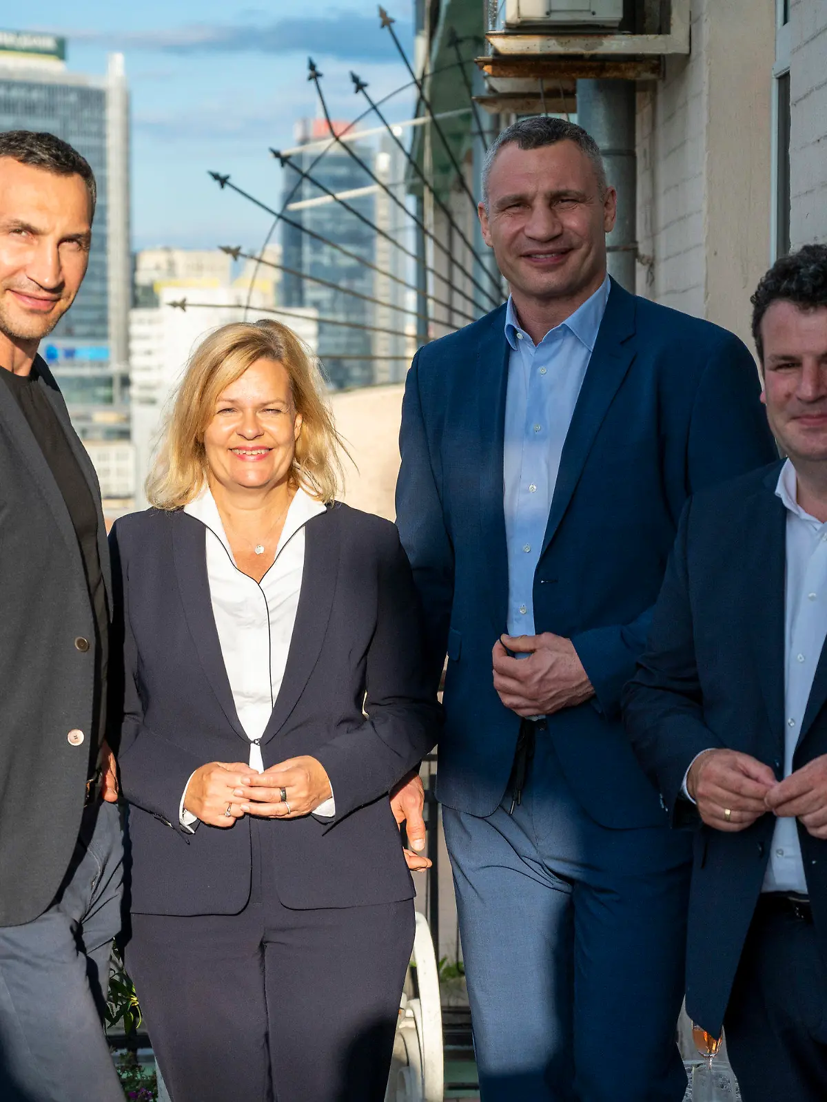 25.07.2022, Ukraine, Kiew: Wladimir Klitschko (l-r), Bruder des Bürgermeisters von Kiew und ehemaliger Boxprofi, Nancy Faeser (SPD), Bundesministerin für Inneres und Heimat, Vitali Klitschko, Bürgermeister von Kiew und ehemaliger Boxprofi, und Hubertus Heil (SPD), Bundesminister für Arbeit und Soziales, stehen auf einem Balkon der Residenz der deutschen Botschafterin in der Ukraine. Foto: Christophe Gateau/dpa +++ dpa-Bildfunk +++