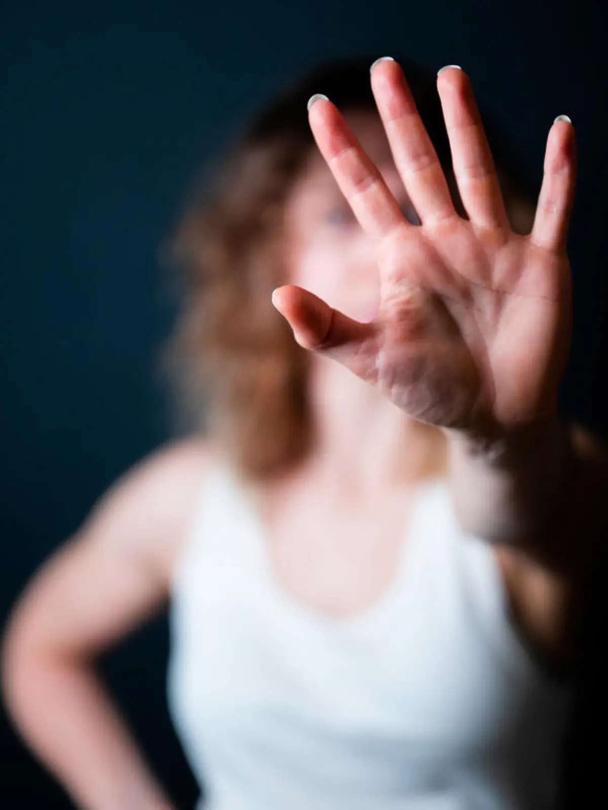 Close-up of a young woman making a stop gesture. Focus on foreground