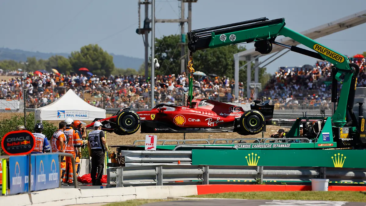 Track marshals remove car of Ferrari driver Charles Leclerc of Monaco after he crashed into the track wall during the French Formula One Grand Prix at Paul Ricard racetrack in Le Castellet, southern France, Sunday, July 24, 2022. (Eric Gaillard/Pool via AP)