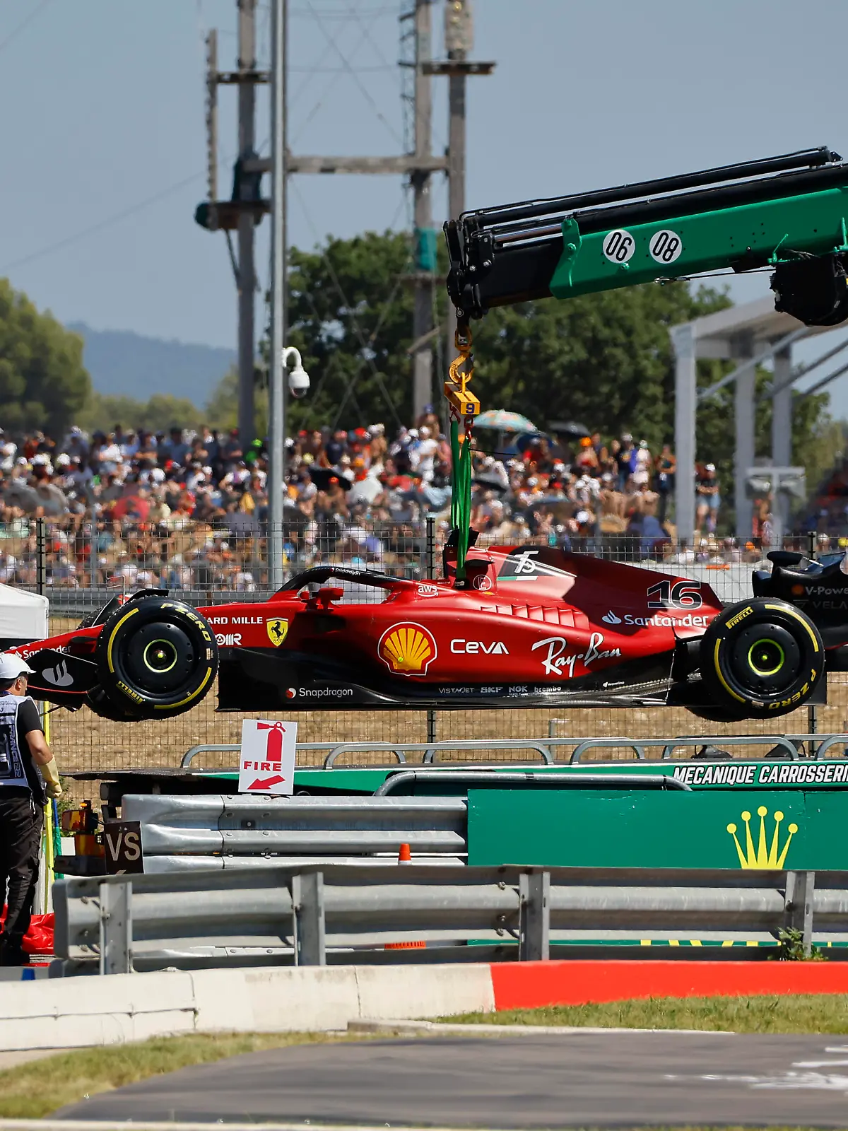 Track marshals remove car of Ferrari driver Charles Leclerc of Monaco after he crashed into the track wall during the French Formula One Grand Prix at Paul Ricard racetrack in Le Castellet, southern France, Sunday, July 24, 2022. (Eric Gaillard/Pool via AP)