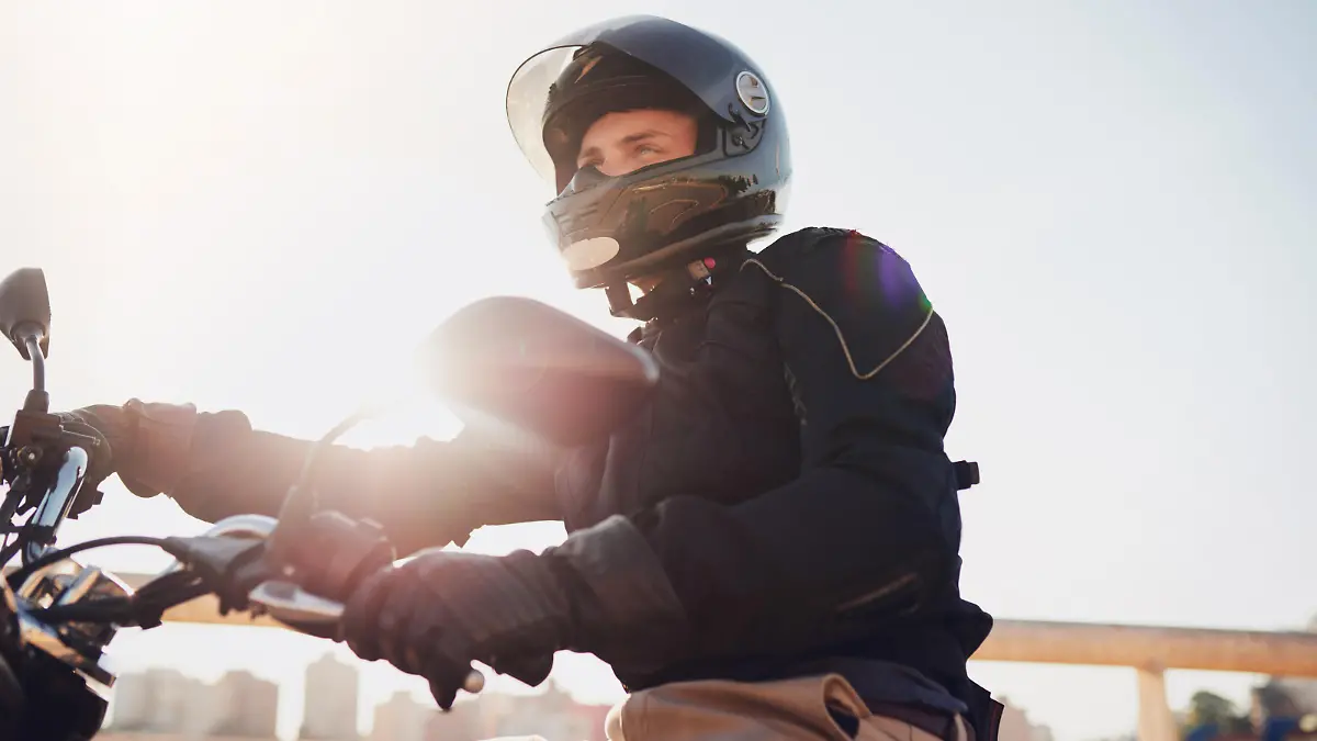 Shot of a young man riding a motorbike through the city