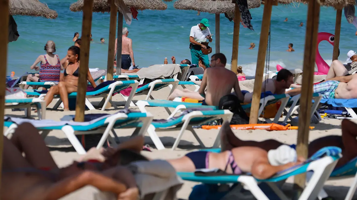 15.08.2020, Spanien, Palma: Menschen sonnen sich und schwimmen am Strand von Arenal auf Mallorca. Angesichts erhöhter Ansteckungsgefahren hat die Bundesregierung fast ganz Spanien einschließlich Mallorca als Risikogebiet eingestuft. Die Einstufung bedeutet, dass für heimkehrende Urlauber eine Testpflicht auf das Coronavirus greift. Foto: Clara Margais/dpa +++ dpa-Bildfunk +++
