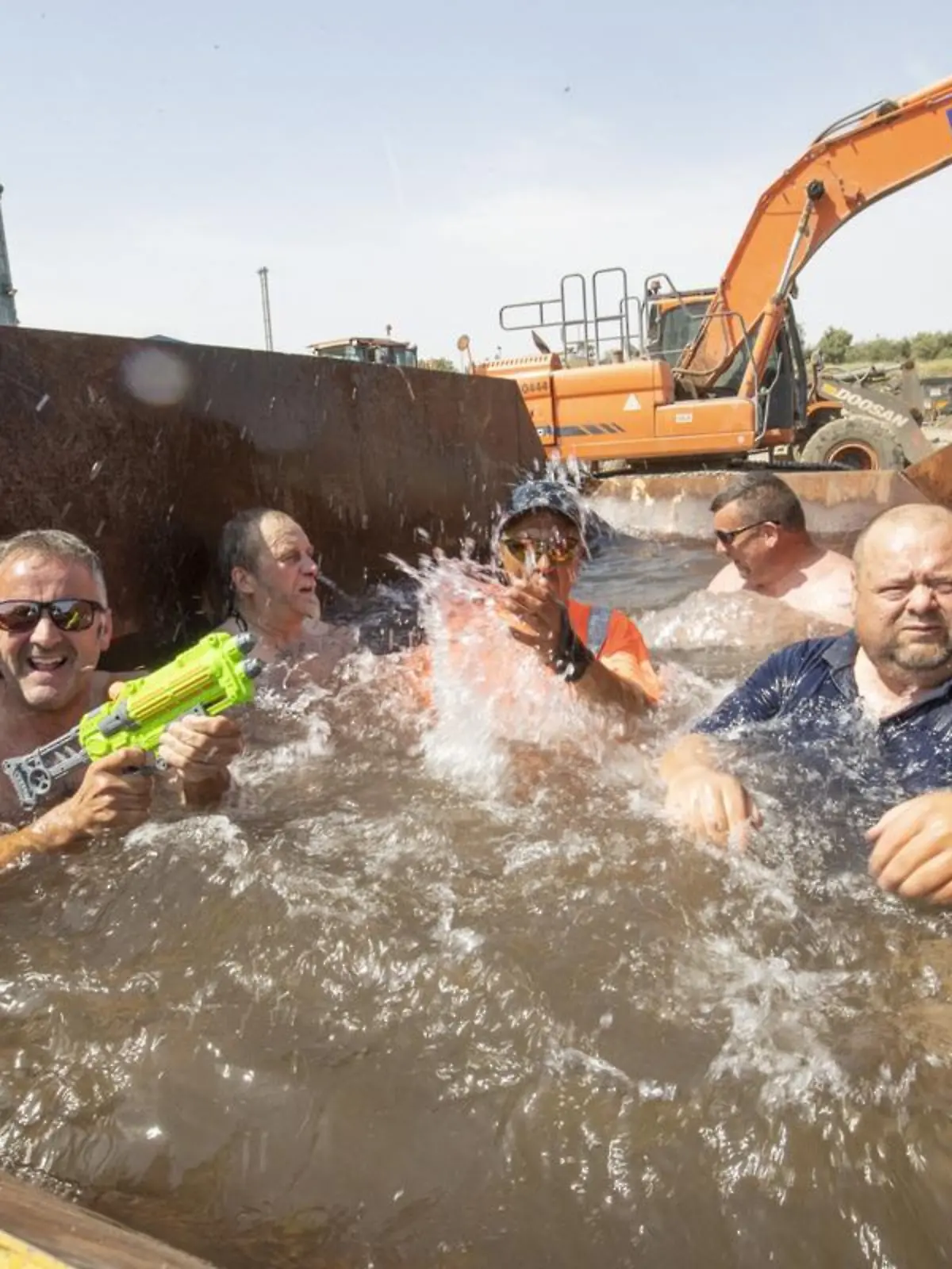Story from Jam Press (Swimming Pool Skip)

Pictured: Employees at Scott Bros enjoying their improvised swimming pool.

‘Almost as good as Benidorm!’: Workers turn rusty SKIP into swimming pool to cool off in summer 

A company in Stockton took matters into their own hands this week in a bid to help cool down its employees – by turning one of their rusty skips into a makeshift swimming pool.

As temperatures reached a scorching 38 degrees in Teeside earlier this week, employees at Scott Bros, a family-run large haulage and plant hire business, were desperate for a way to cool down as they worked away in the heat.

Peter Scott, 46, company director, took matters into his own hands and decided to fill one of their empty skips with water. 

"It might look a little strange, but a large skip makes the perfect plunge pool," Peter told NeedToKnow.online. 

"We had no shortage of people asking if they could take a quick dip. 

"It was also a bit of fun, while allowing people a well-deserved break.

"It really helped our staff to completely cool down."

To ensure the skip was safe for employers, the company cleaned it out with a pressure washer and inserted plastic sheeting in the bottom.

As a recycling firm, they then filled up the skip with recycled water from their bowser.

Peter said: "Everyone really loved it, partly because at heart we are a recycling firm, and we were following the company ethos by taking an empty skip and repurposed it as a plunge pool! 

"There was plenty of mickey taking and laughter, but those who took a turn really enjoyed themselves. 

"We even found a couple of squirter guns to add to the fun.”

Neil Crawford, a machine operator at Scott Bros, was one of the employees who took the plunge.

He said: “We’ve been happy to get on with our jobs despite the heat, but this is a proper treat. 

"It’s almost as good as being by the pool in Benidorm!”

Peter has said that a lot of people have dismissed the creativity as a "stunt" but says