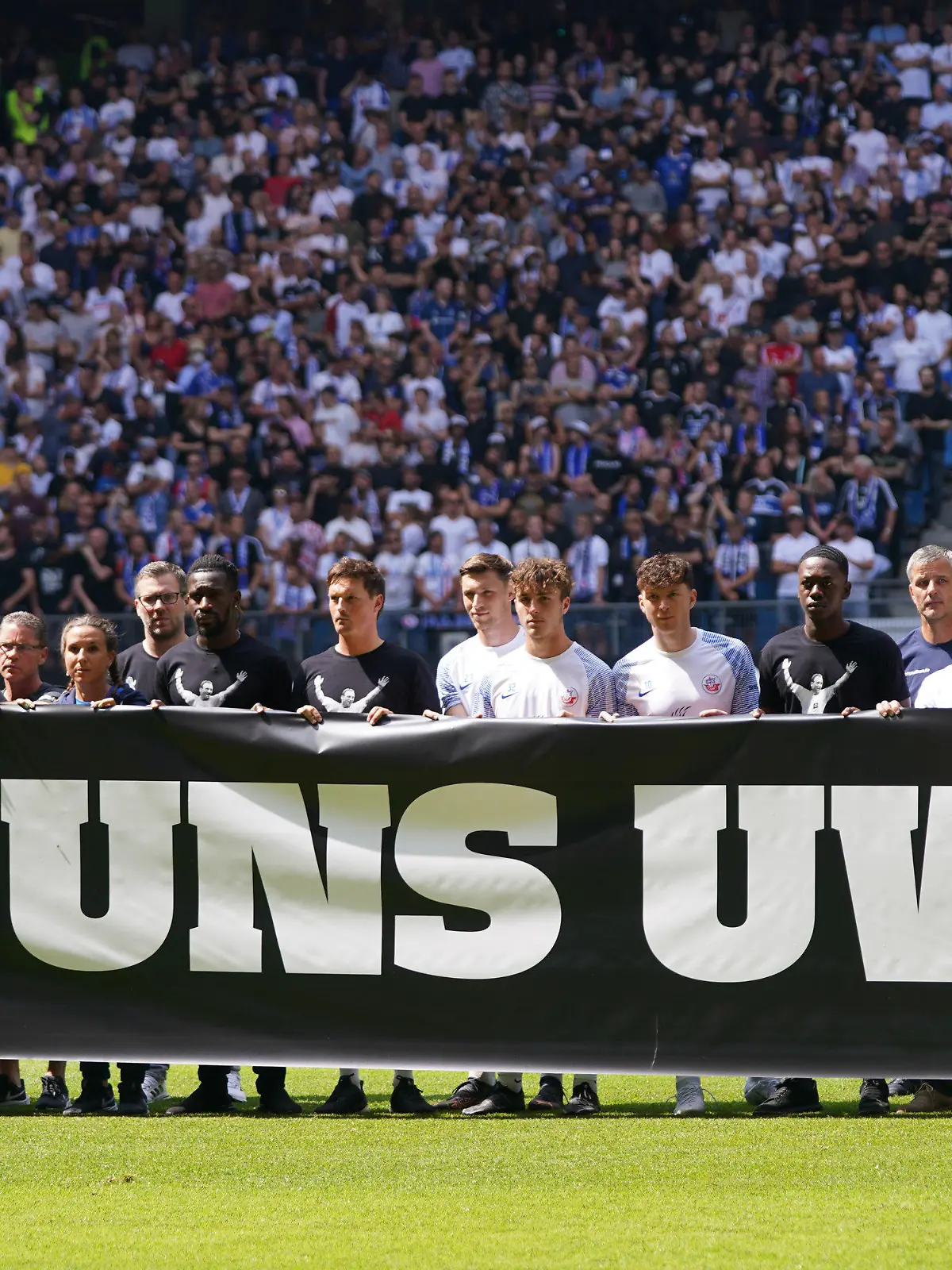 24.07.2022, Hamburg: Fußball: 2. Bundesliga, 2. Spieltag, Hamburger SV - Hansa Rostock, im Volksparkstadion. Die Spieler halten ein Banner mit der Aufschrift «Uns Uwe» hoch und Gedenken damit dem verstorbenen Uwe Seeler. Foto: Marcus Brandt/dpa - WICHTIGER HINWEIS: Gemäß den Vorgaben der DFL Deutsche Fußball Liga bzw. des DFB Deutscher Fußball-Bund ist es untersagt, in dem Stadion und/oder vom Spiel angefertigte Fotoaufnahmen in Form von Sequenzbildern und/oder videoähnlichen Fotostrecken zu verwerten bzw. verwerten zu lassen. +++ dpa-Bildfunk +++