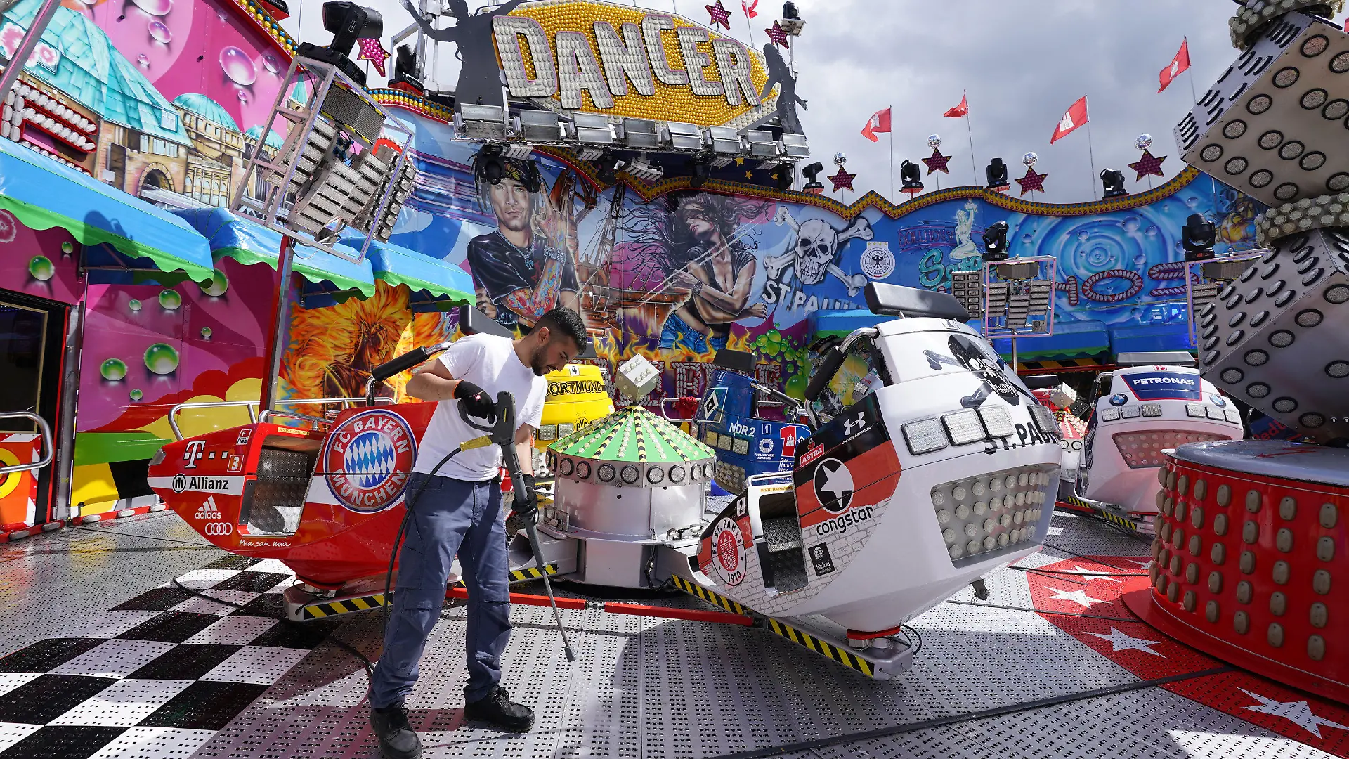 PRODUKTION - 15.07.2022, Hamburg: Ein Mitarbeiter reinigt das Fahrgeschäft Dom Dancer auf dem Heiligengeistfeld. Am 22. Juli wird das Volksfest, der Hamburger Sommerdom, eröffnet. Foto: Marcus Brandt/dpa +++ dpa-Bildfunk +++