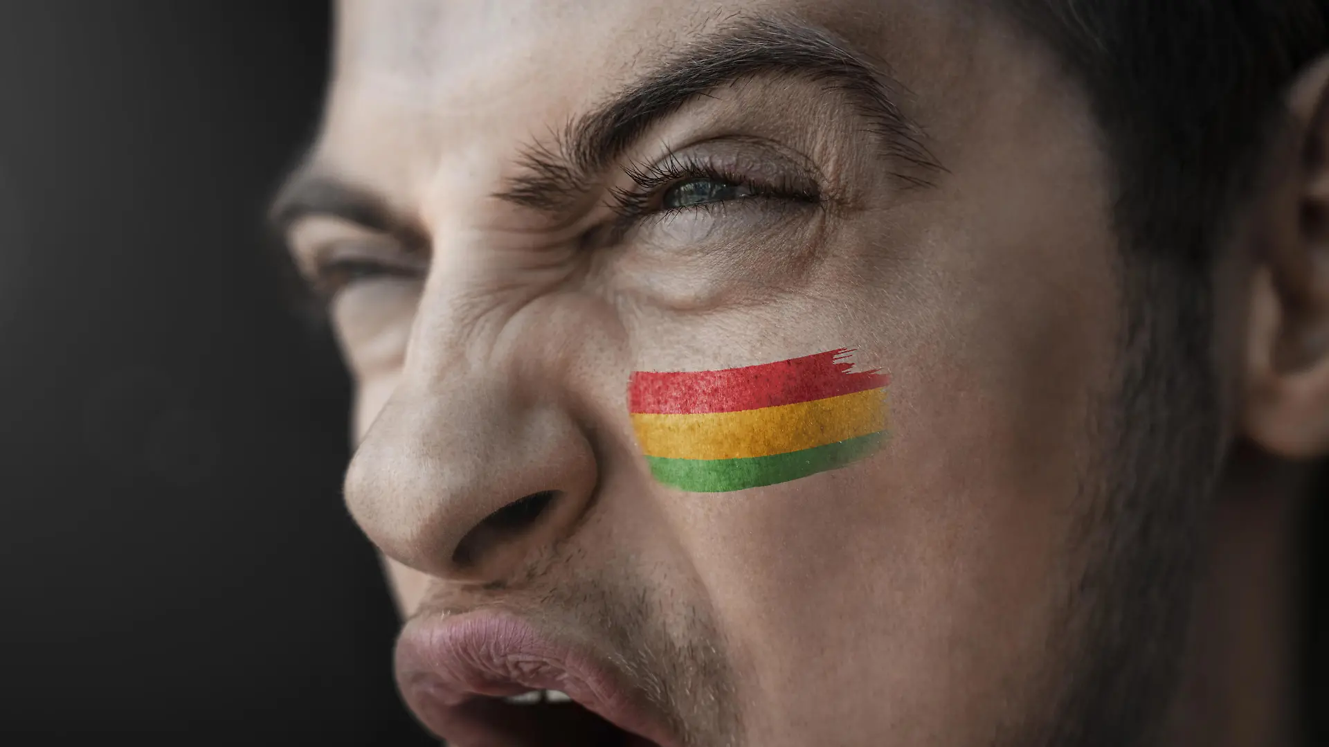 A screaming man with the image of the Bolivia national flag on his face. || Modellfreigabe vorhanden