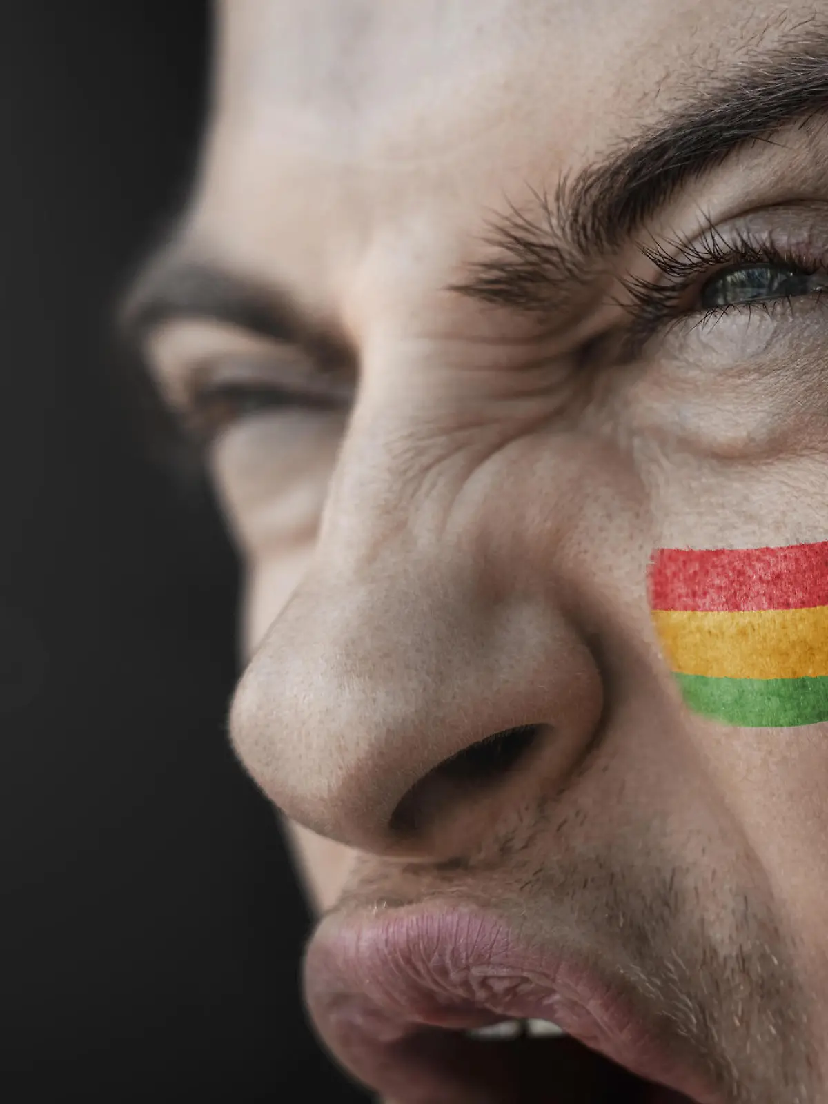 A screaming man with the image of the Bolivia national flag on his face. || Modellfreigabe vorhanden