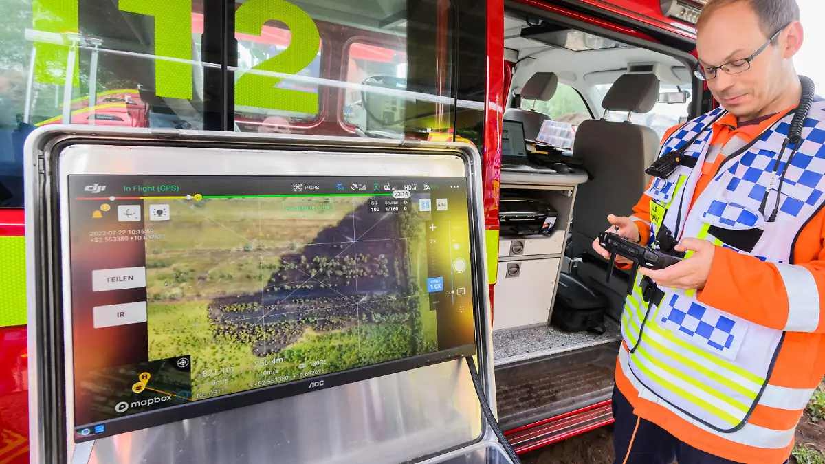 22.07.2022, Niedersachsen, Sassenburg: Ein Drohnenpilot der Feuerwehr unterstützt die Löscharbeiten im Großen Moor im Landkreis Gifhorn. Am Donnerstag war im Moor ein Feuer auf einer Fläche der Größe von rund 35 Fußballfeldern ausgebrochen. Die Löscharbeiten werden nach Angaben der Feuerwehr voraussichtlich mehrere Tage andauern. Foto: Julian Stratenschulte/dpa +++ dpa-Bildfunk +++