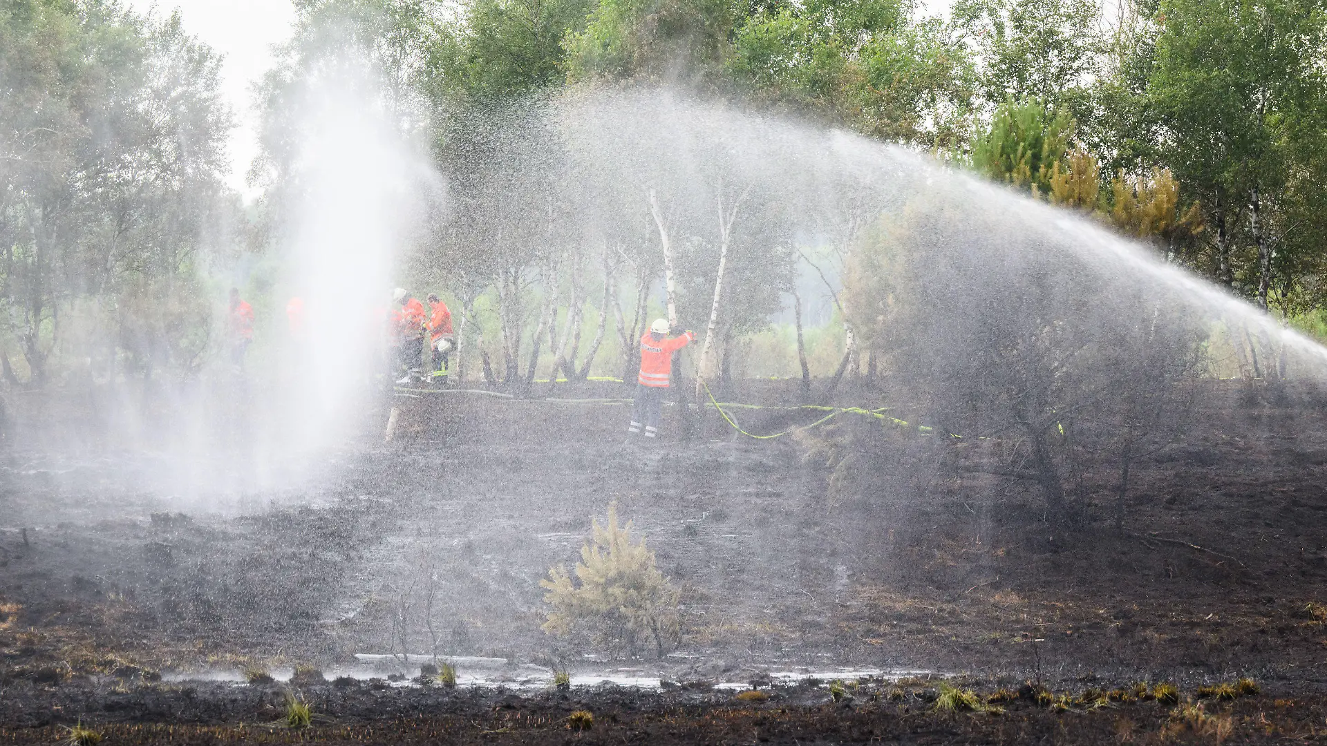 22.07.2022, Niedersachsen, Sassenburg: Feuerwehrkräfte löschen einen Brand im Großen Moor im Landkreis Gifhorn. Am Donnerstag war im Moor ein Feuer auf einer Fläche der Größe von rund 35 Fußballfeldern ausgebrochen. Die Löscharbeiten werden nach Angaben der Feuerwehr voraussichtlich mehrere Tage andauern. Foto: Julian Stratenschulte/dpa +++ dpa-Bildfunk +++