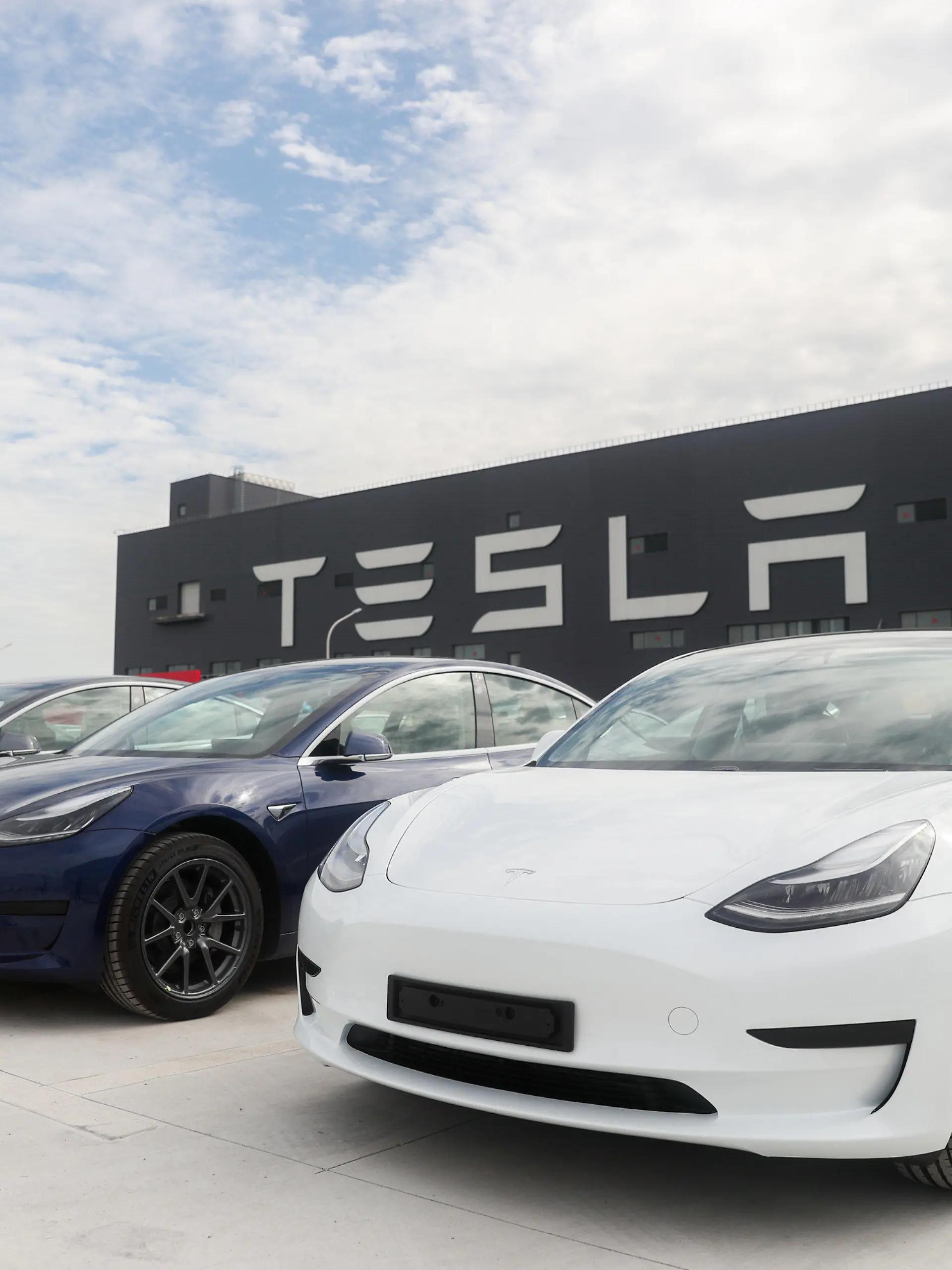 ARCHIV - 26.10.2020, China, Shanghai: Fahrzeuge des Models 3 stehen vor der Tesla Fabrik. Ein zunächst ausgesprochenes Verbot für Autos der Marke Tesla wegen ihrer vielen Kameras auf bestimmten Grundstücken der Berliner Polizei hat für Aufsehen und Irritationen gesorgt. (zu dpa: «Tesla-Autos mit Kameras auf Polizei-Gelände? - Irritationen um Verbot») Foto: Ding Ting/XinHua/dpa +++ dpa-Bildfunk +++