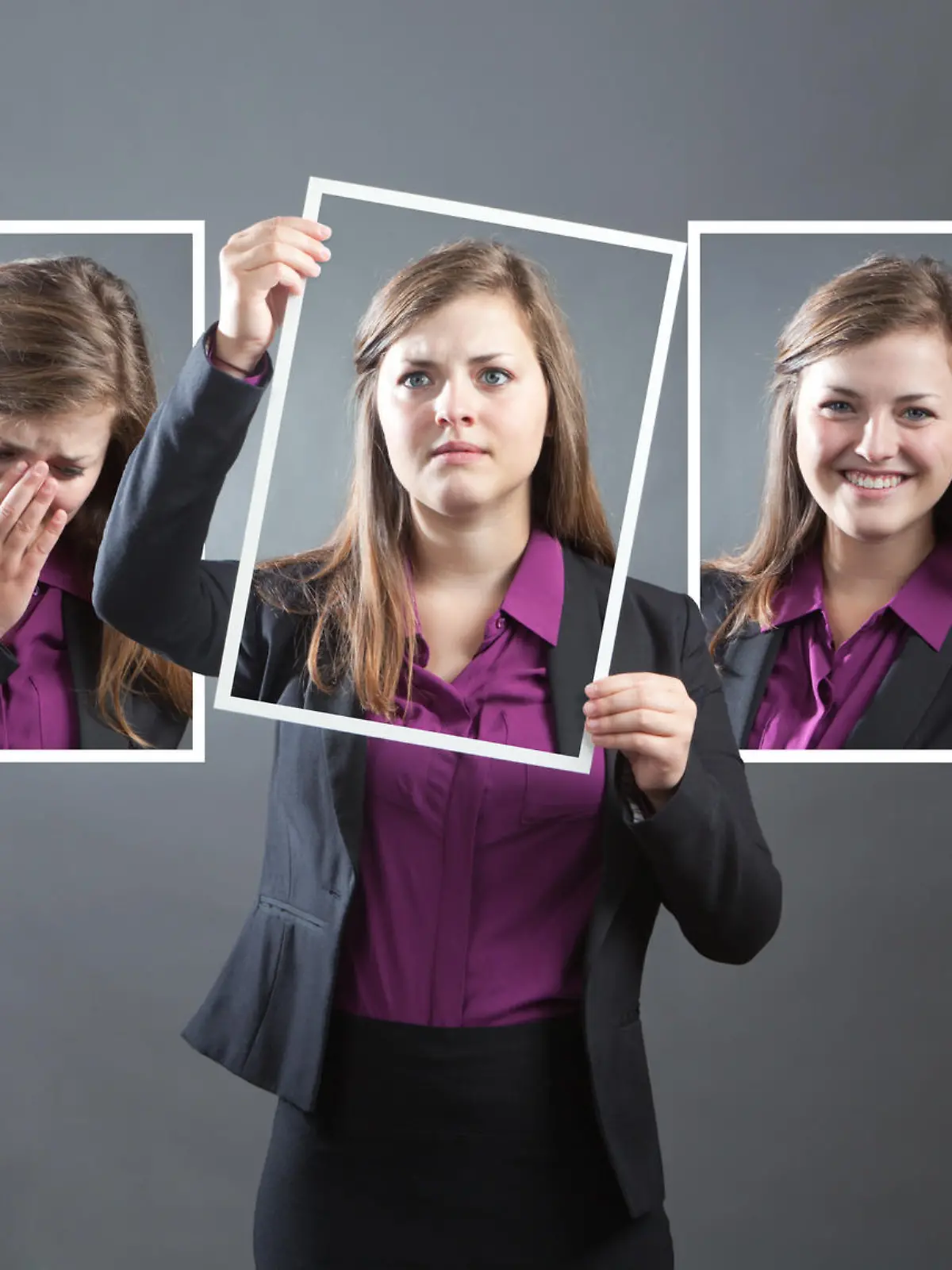 Concept photo for personality, character and emotional expression. A woman in business suit holding up a photo of herself in front of her with various range of emotional expressions exhibited in the background wall behind her. From happiness to sadness, anger to joy, apprehension to confidence. Photographed in panoramic horizontal format in studio.