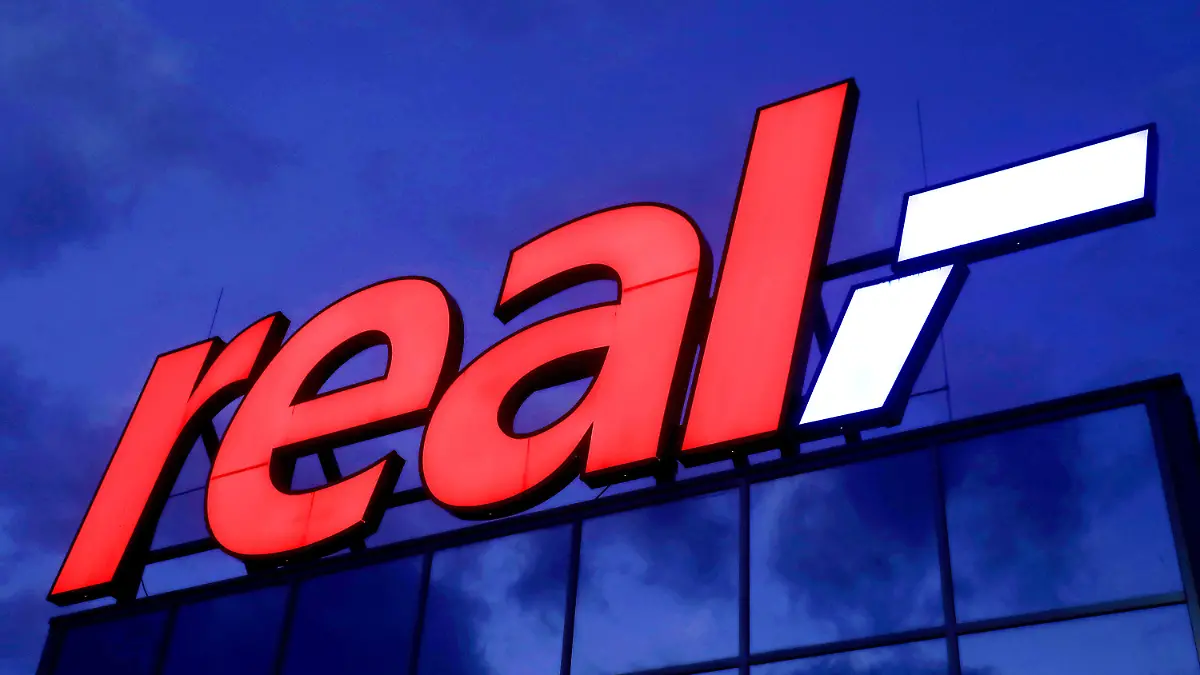 ARCHIV - 17.01.2020, Nordrhein-Westfalen, Köln: Das Logo leuchtet am Morgen auf dem Dach eines Real Warenhauses. (Zu dpa "Kartellamt gibt Edeka grünes Licht für Übernahme von 51 Real-Märkten ") Foto: Oliver Berg/dpa +++ dpa-Bildfunk +++