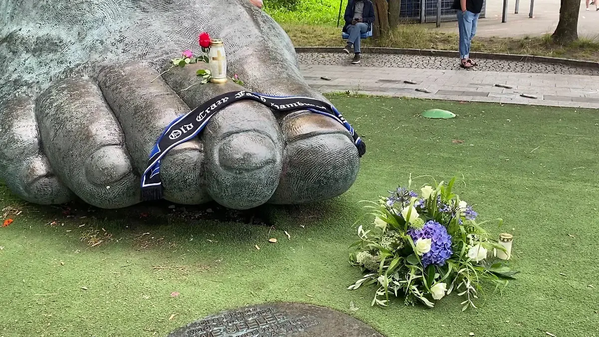 Trauer um Uwe Seeler - Trauernde haben Kerzen und einen Schal auf die Bronze-Skulptur von Uwe Seelers Fuß im Altonaer Volkspark gelegt