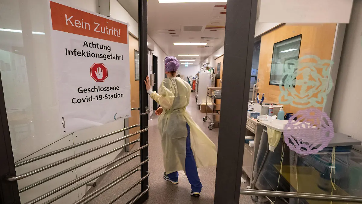 ARCHIV - 17.11.2021, Baden-Württemberg, Stuttgart: Eine Krankenpflegerin betritt einen abgetrennten Bereich für Covid-19 Patienten einer Intensivstation des Klinikum Stuttgart. Weil immer mehr Mitarbeiter wegen Krankheit ausfallen, können viele Krankenhäuser im Südwesten weniger Betten für Patienten nutzen. (zu dpa: «Krankheitsfälle belasten Kliniken - Teils werden Eingriffe verschoben») Foto: Marijan Murat/dpa +++ dpa-Bildfunk +++