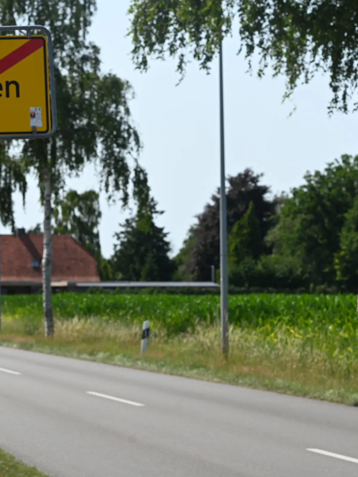 19.07.2022, Niedersachsen, Veenhusen: Ein Mann macht Fotos vom Ortsausgangsschild «Emden» in der ostfriesischen Gemeinde Moormerland im Ortsteil Veenhusen. Unbekannte haben in der ostfriesischen Gemeinde Moormerland im Ortsteil Veenhusen gleich drei gelbe Ortsschilder abmontiert und mit Ortschildern aus Emden ersetzt. Bislang seien die Veenhusen-Schilder, die pro Stück rund 350 Euro kosten, noch nicht wieder aufgetaucht. Foto: Lars Klemmer/dpa +++ dpa-Bildfunk +++