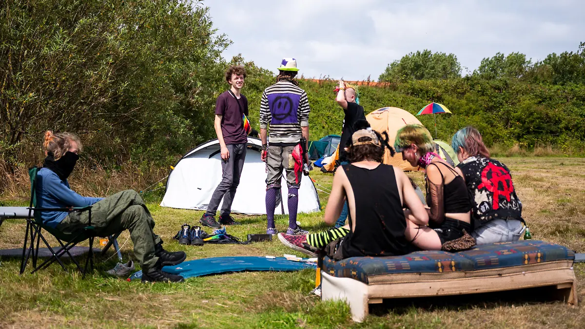 24.07.2023, Schleswig-Holstein, Tinnum / Sylt: Punks sitzen in Tinnum auf der Wiese eines Protestcamps. Unter dem Motto «Sylt für alle» kritisiert die Gruppe ·Aktion Sylt· eine Spaltung der Gesellschaft und hat ein mehrwöchiges Protestcamp auf der Insel gestartet. Foto: Daniel Bockwoldt/dpa - ACHTUNG: Verwendung nur im vollen Format +++ dpa-Bildfunk +++