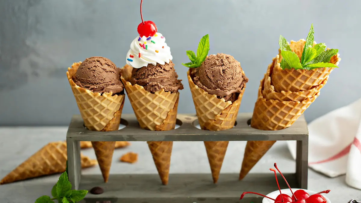 Chocolate ice cream in waffle cones with whipped cream and sprinkles