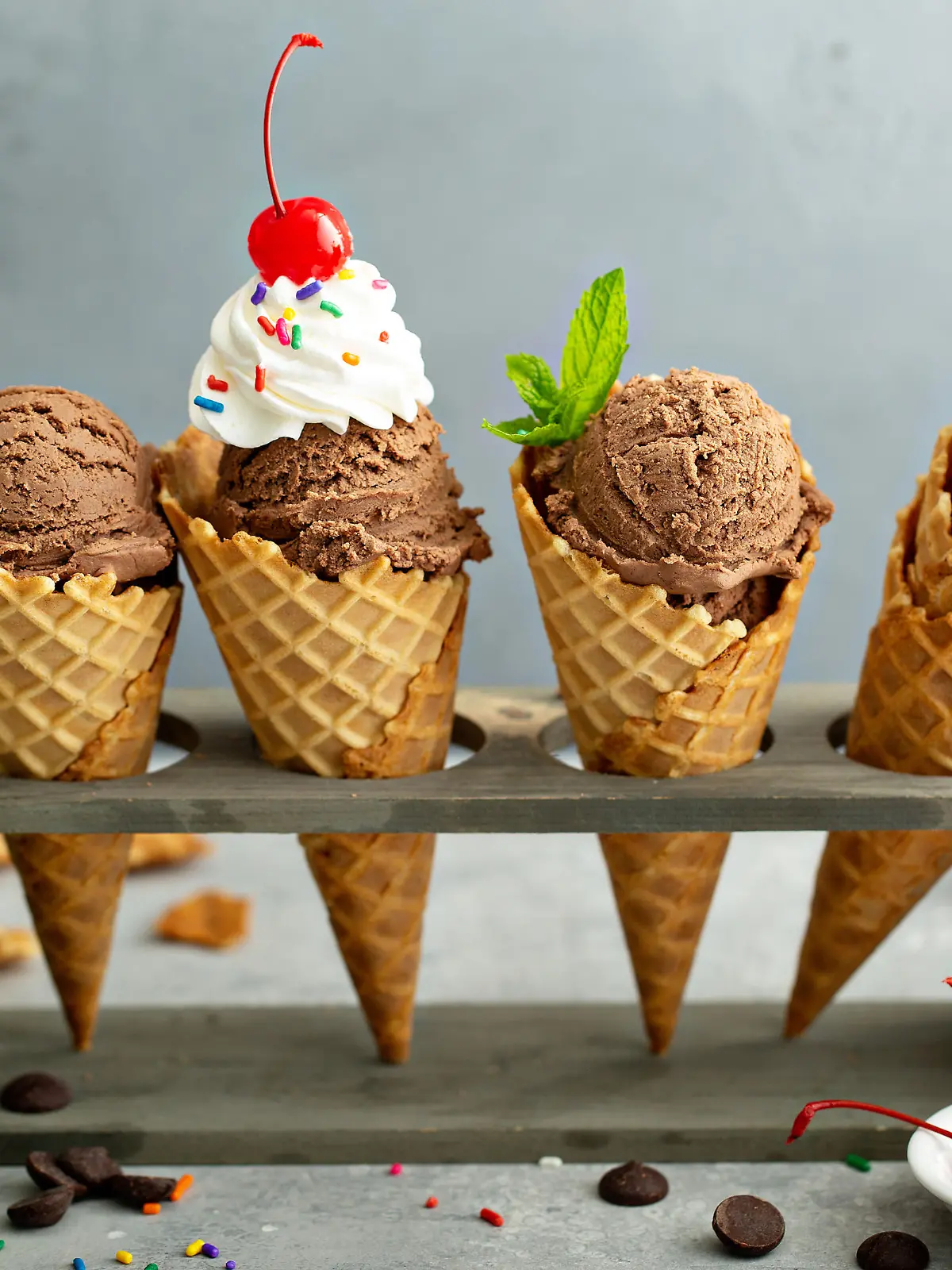 Chocolate ice cream in waffle cones with whipped cream and sprinkles
