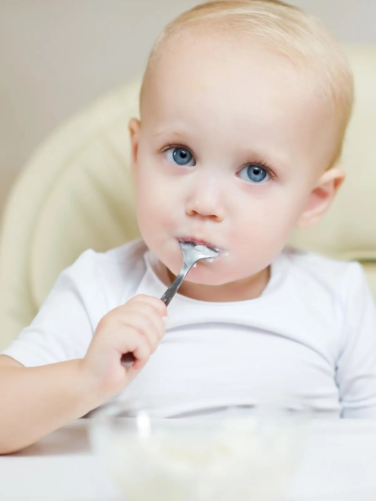 Baby isst Brei mit eigenem Löffel
