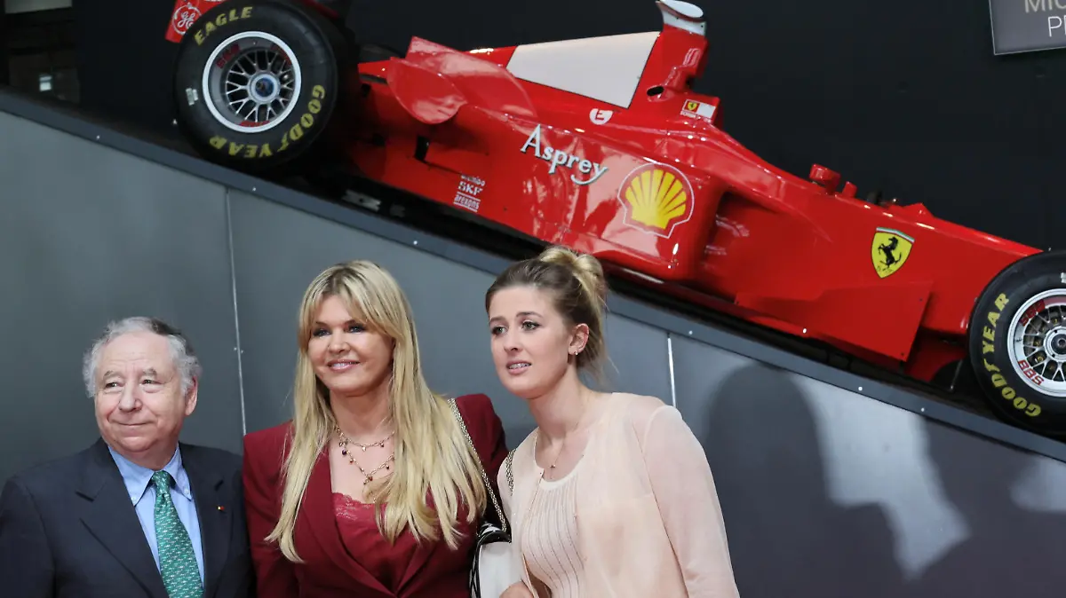 FIA President Jean Todt, Corinna Schumacher and her daughter Gina-Maria pose in front of a F-1 Ferrari racing car of Michael Schumacher as the former Formula One world champion receives the North-Rhine Westphalian (NRW) state prize in Cologne, Germany July 20, 2022. REUTERS/Wolfgang Rattay