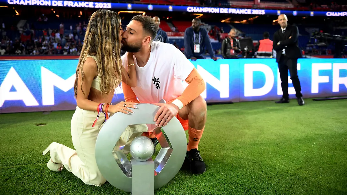 FILE - Paris Saint-Germain's Italian goalkeeper Gianluigi Donnarumma kisses his partner as they pose with the trophy following the team's French League One soccer match loss to Clermont, in Paris, Saturday, June 3, 2023. French police are investigating a violent armed robbery that targeted Paris Saint-Germain goalkeeper Gianluigi Donnarumma at his home. The Paris prosecutor's office said Friday July 21, 2023 the player was targeted overnight Thursday to Friday. (Franck Fife/Pool Photo via AP, File)