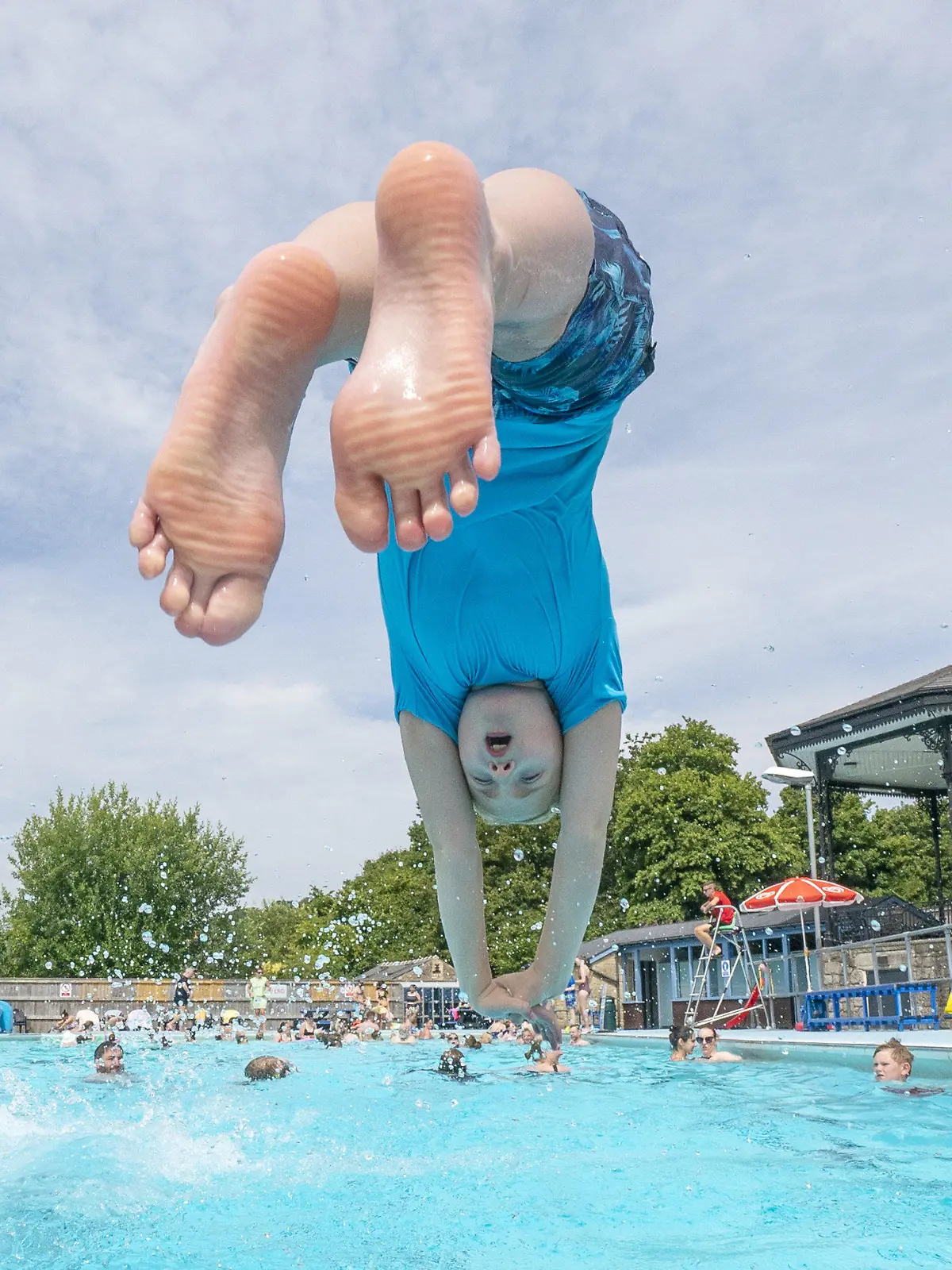 17.07.2022, Großbritannien, Hathersage: Ein Junge springt in ein Schwimmbecken im Freibad von Hathersage. Die Temperaturen in Hathersage steigen in den kommenden Tagen auf über 30 Grad Celsius. Foto: Danny Lawson/PA Wire/dpa +++ dpa-Bildfunk +++