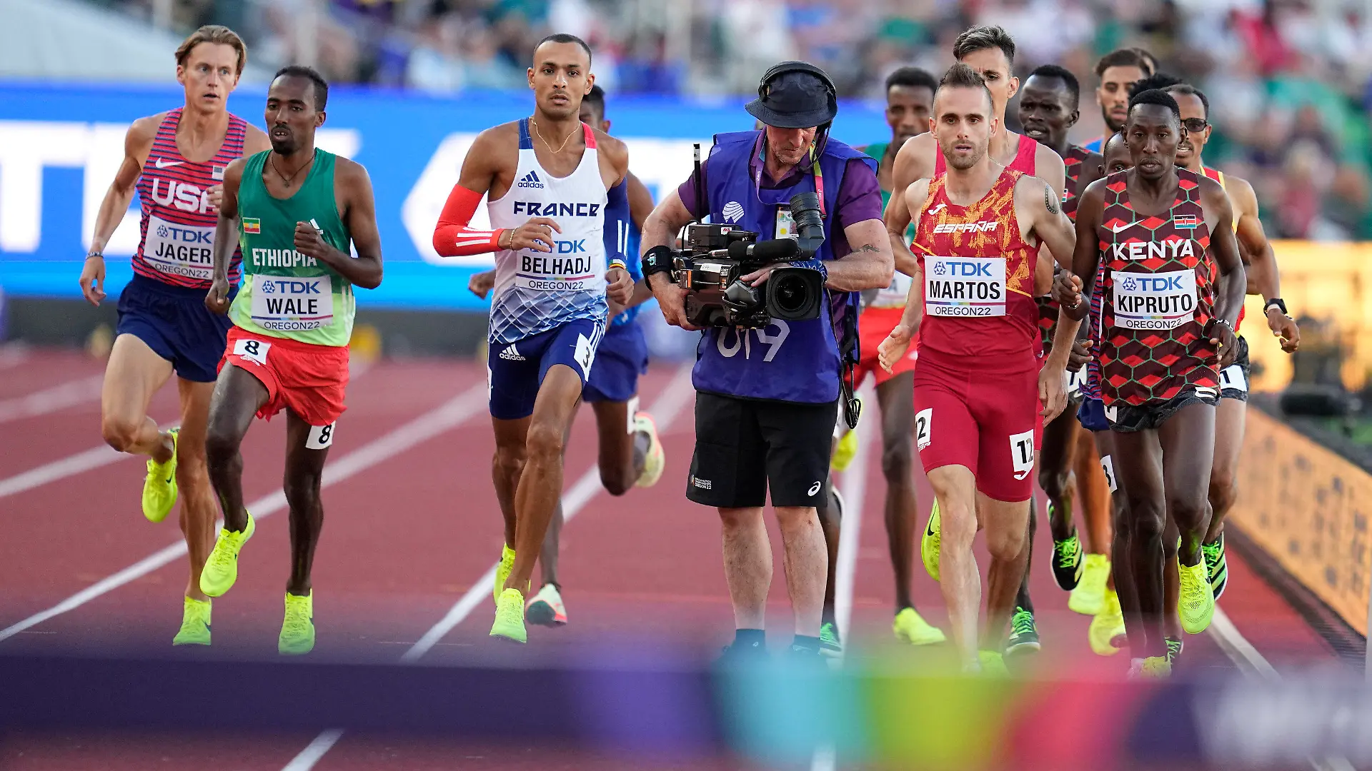 Men compete and move around a camera person on the track during the men's 3000-meter steeplechase final at the World Athletics Championships on Monday, July 18, 2022, in Eugene, Ore. (AP Photo/Ashley Landis)