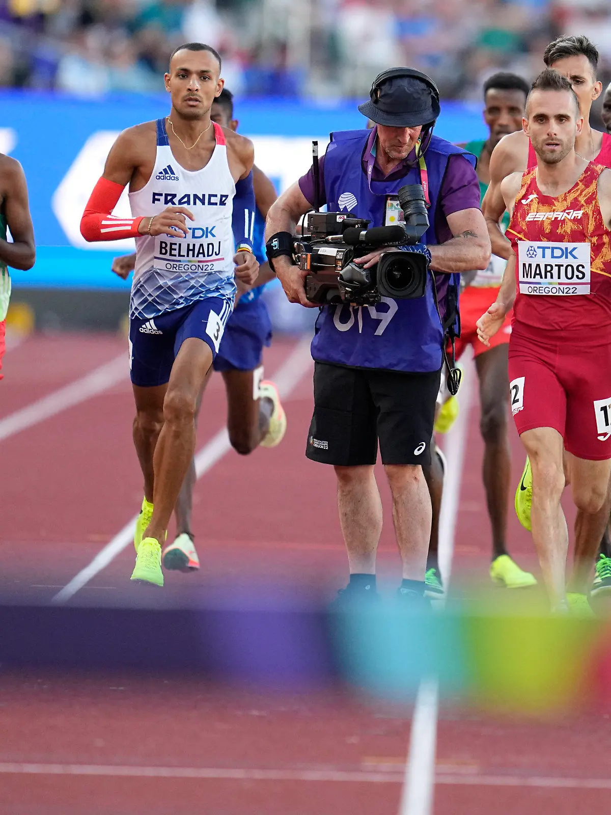 Men compete and move around a camera person on the track during the men's 3000-meter steeplechase final at the World Athletics Championships on Monday, July 18, 2022, in Eugene, Ore. (AP Photo/Ashley Landis)