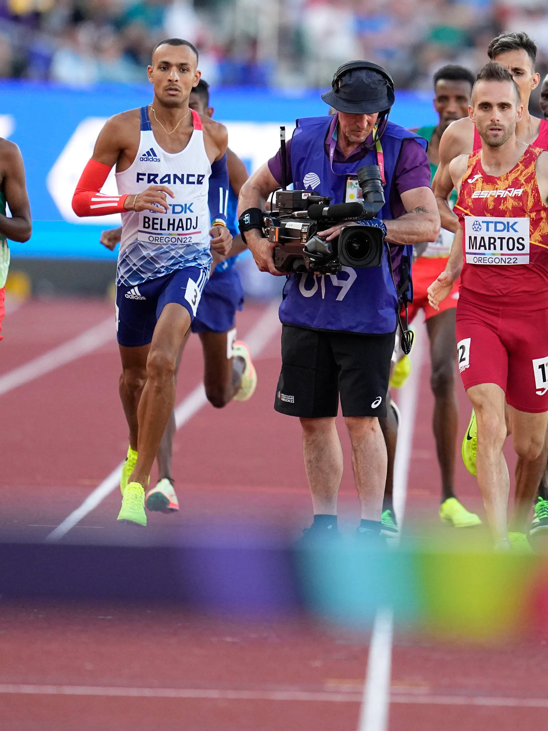 Men compete and move around a camera person on the track during the men's 3000-meter steeplechase final at the World Athletics Championships on Monday, July 18, 2022, in Eugene, Ore. (AP Photo/Ashley Landis)