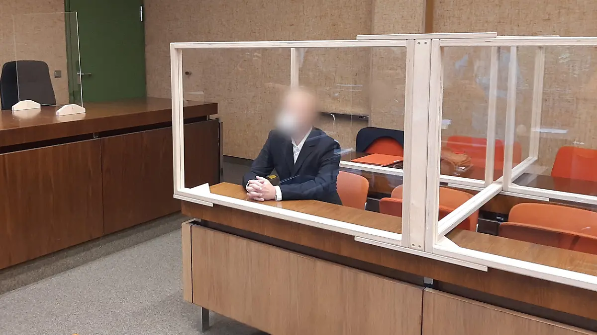 07.07.2022, Bayern, München: Der Angeklagte sitzt auf der Anklagebank und wird von einem Fotografen fotografiert. Dem Mann wirft die Staatsanwaltschaft vor, die beiden im rheinland-pfälzischen Kusel getöteten Polizisten verunglimpft haben. Foto: Britta Schultejans/dpa +++ dpa-Bildfunk +++