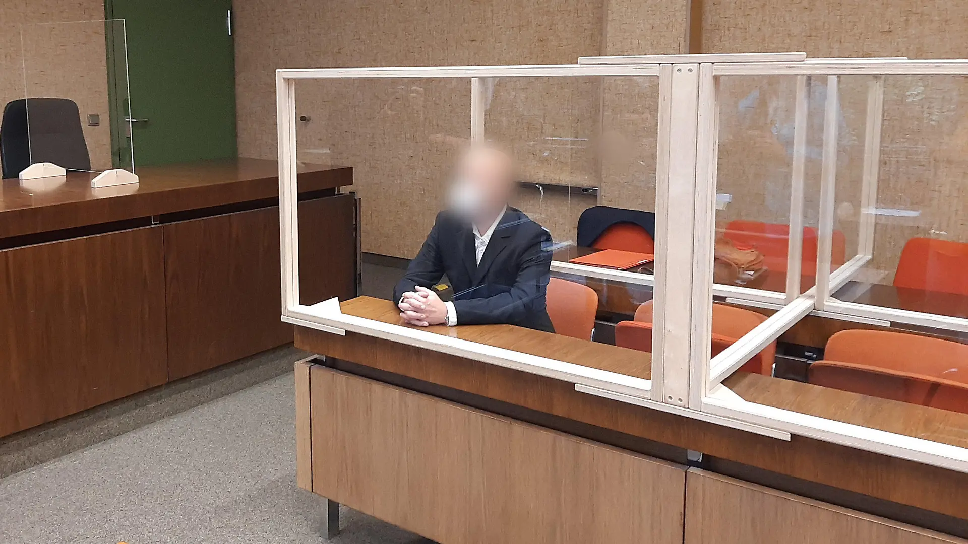 07.07.2022, Bayern, München: Der Angeklagte sitzt auf der Anklagebank und wird von einem Fotografen fotografiert. Dem Mann wirft die Staatsanwaltschaft vor, die beiden im rheinland-pfälzischen Kusel getöteten Polizisten verunglimpft haben. Foto: Britta Schultejans/dpa +++ dpa-Bildfunk +++